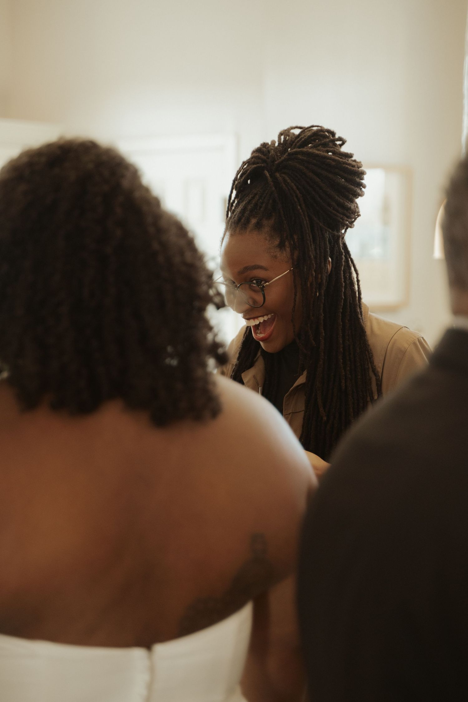 A wedding guest smiles while she holds a central Virginia bride's hand at their surprise ceremony outside Richmond