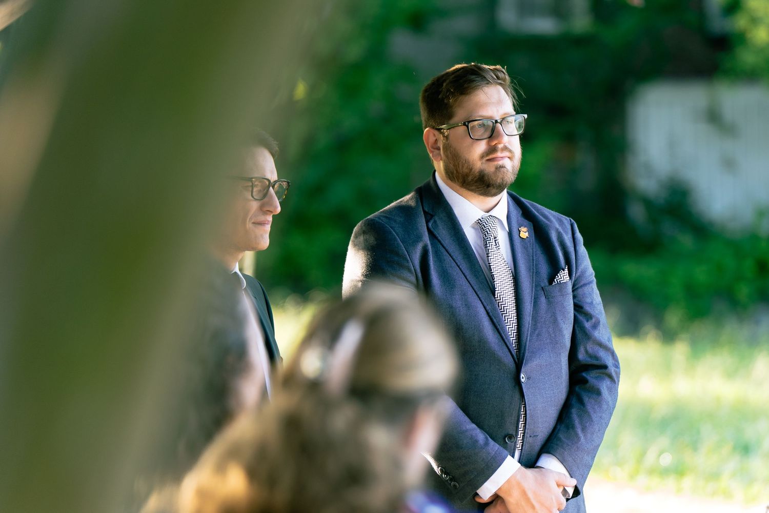 Two groomsmen look on as their friend gets married during an intimate ceremony at Libby Hill Park in Richmond Virginia