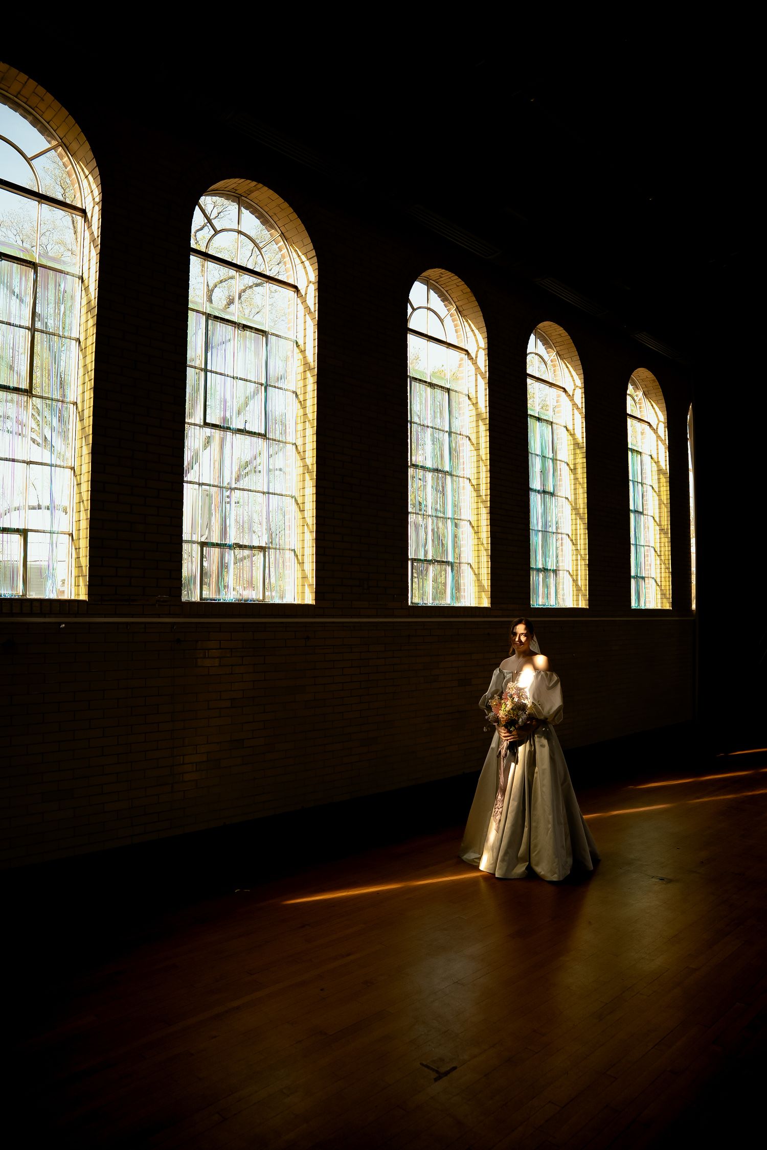 Documentary style wedding photo by New England wedding photographer Daniel Bowler of bride in classic dress and dark romance venue