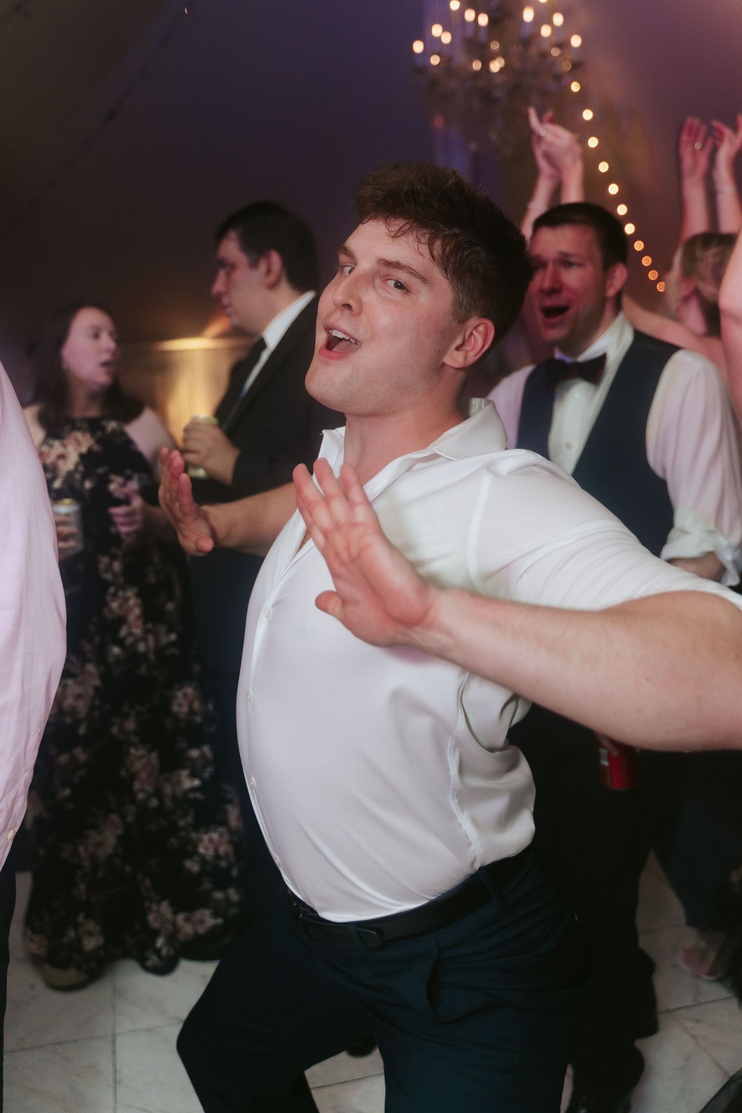 Wedding guest dances and makes eye contact with the camera lens as he gets down during a wedding at Mankin Mansion outside Richmond Virginia
