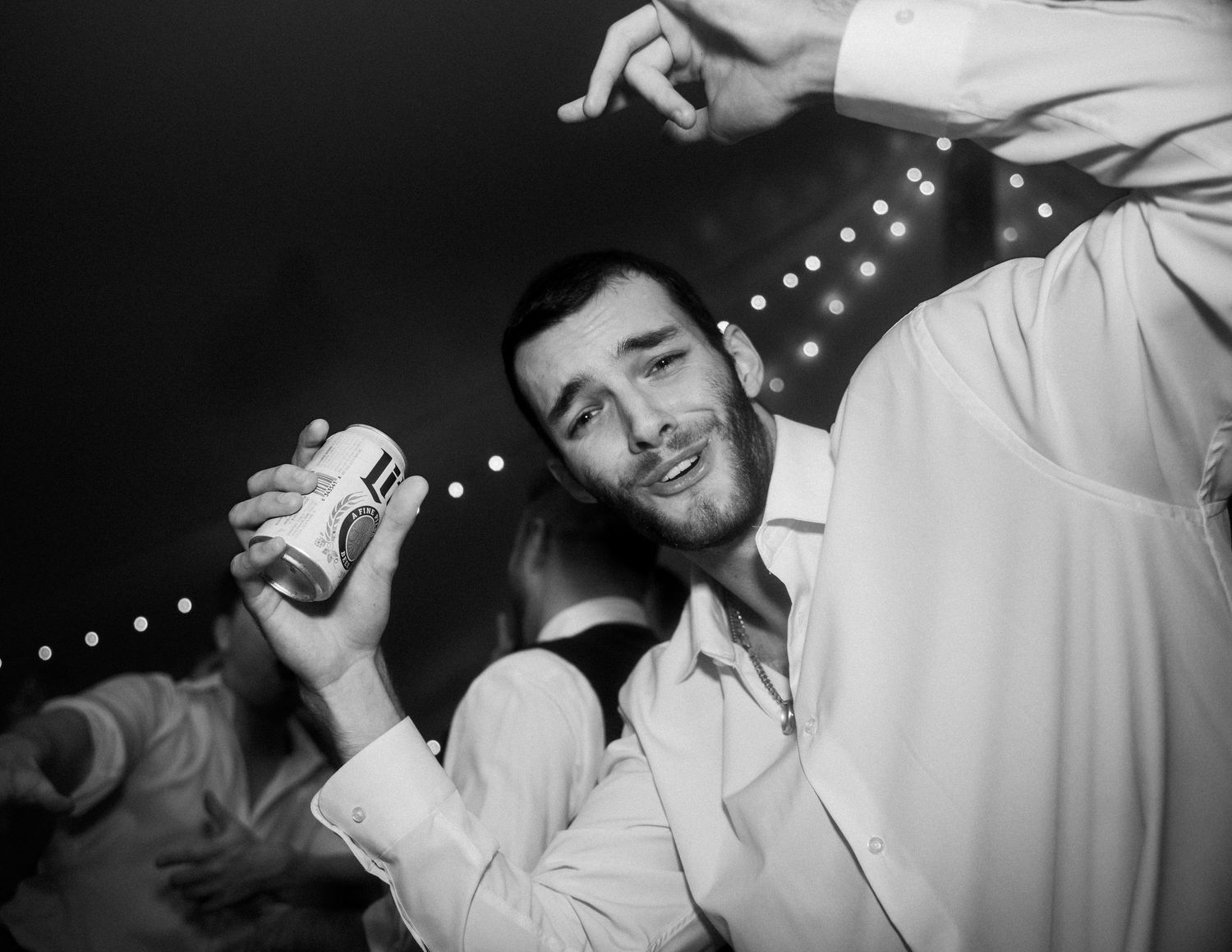 A wedding guest holding a beer sings for the camera during the dance party of a wedding at Mankin Mansion outside Richmond Virginia