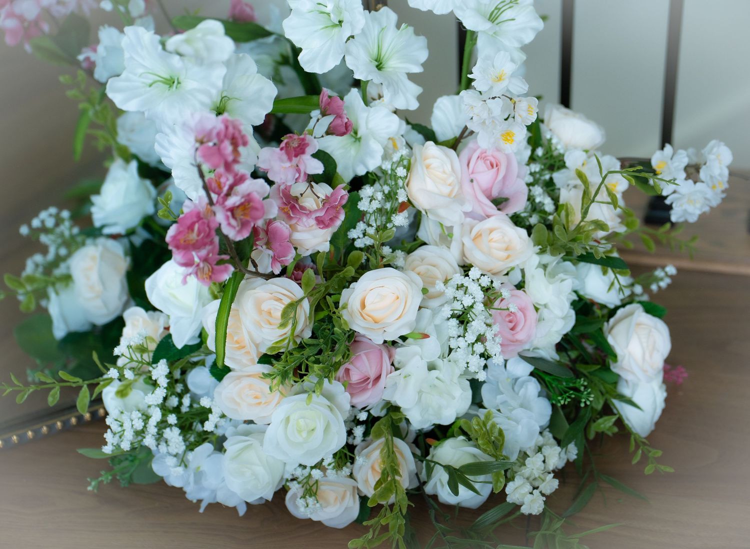 Lush white and pink flower bouquet with roses, gypsophila, and greenery.