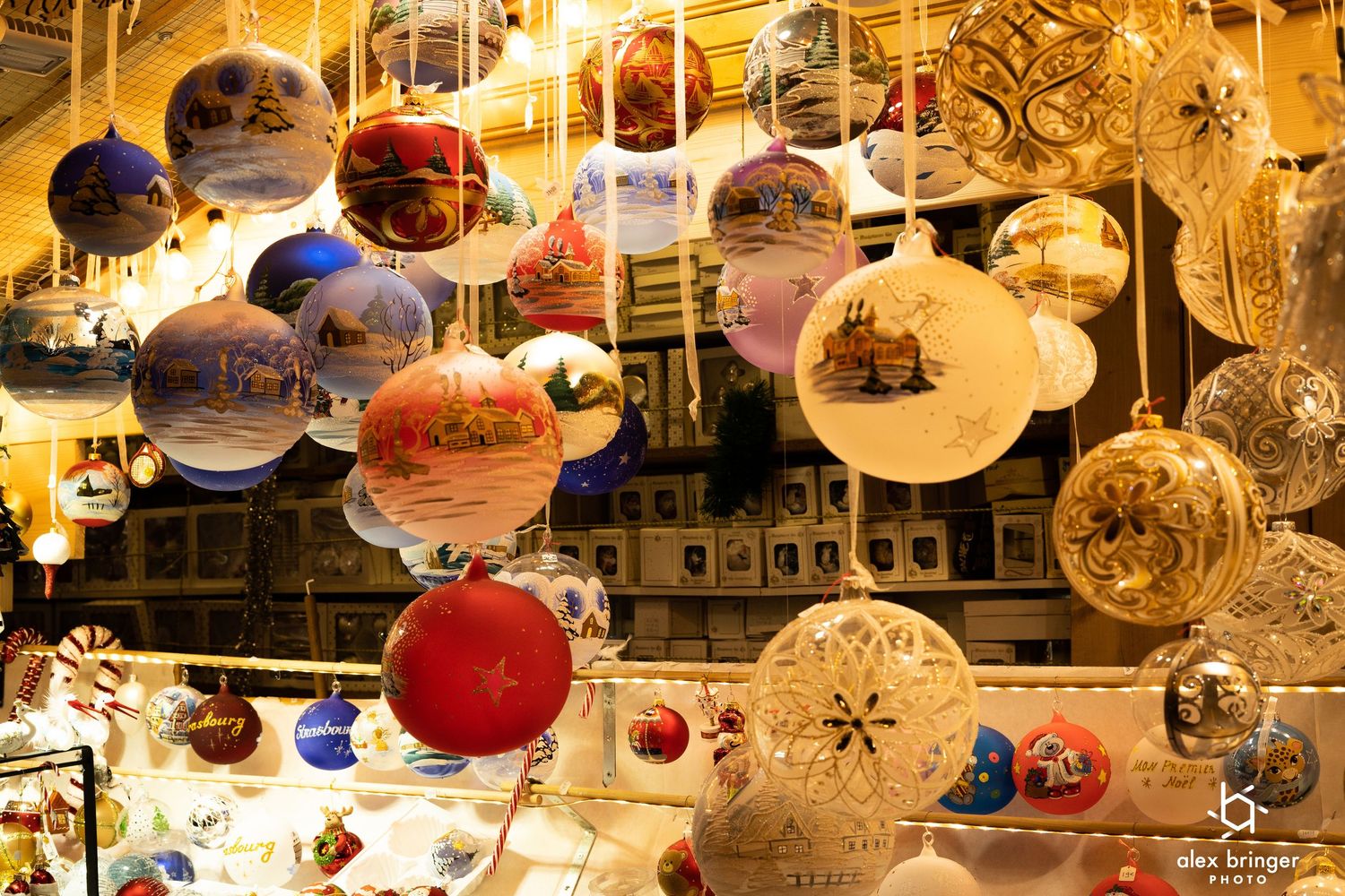 Colorful hand-painted Christmas ornament balls hanging at a festive holiday market display stall.