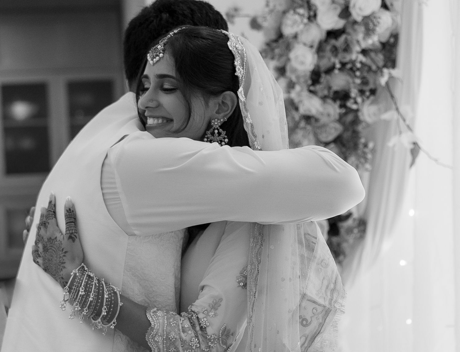 Black and white photo of newlywed couple sharing emotional embrace after Muslim wedding ceremony.