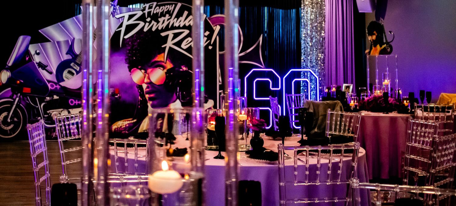 Elegant 60th birthday party venue decorated in purple and black with motorcycle theme and Happy Birthday Zeci sign.