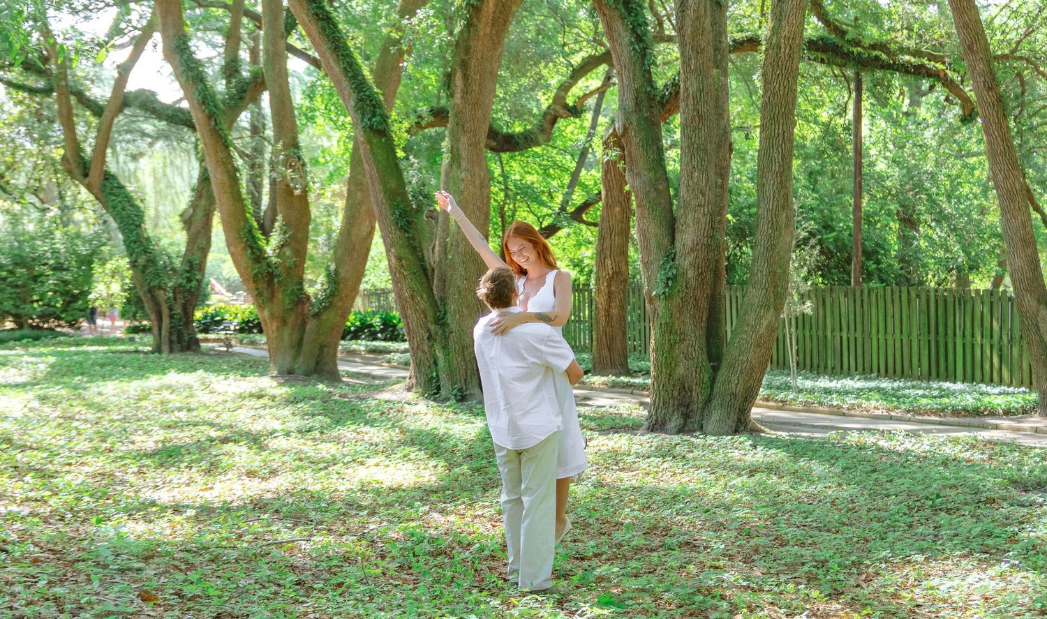 Engaged woman dancing among the trees during an Aiken, South Carolina engagement session.
