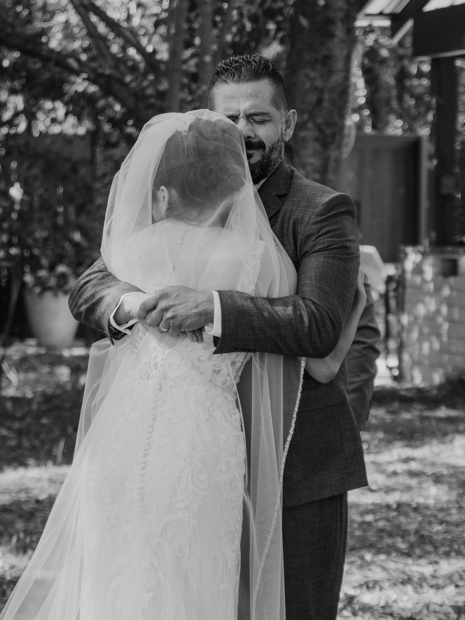 A black and white wedding photo series showing intimate moments between a couple in formal attire.