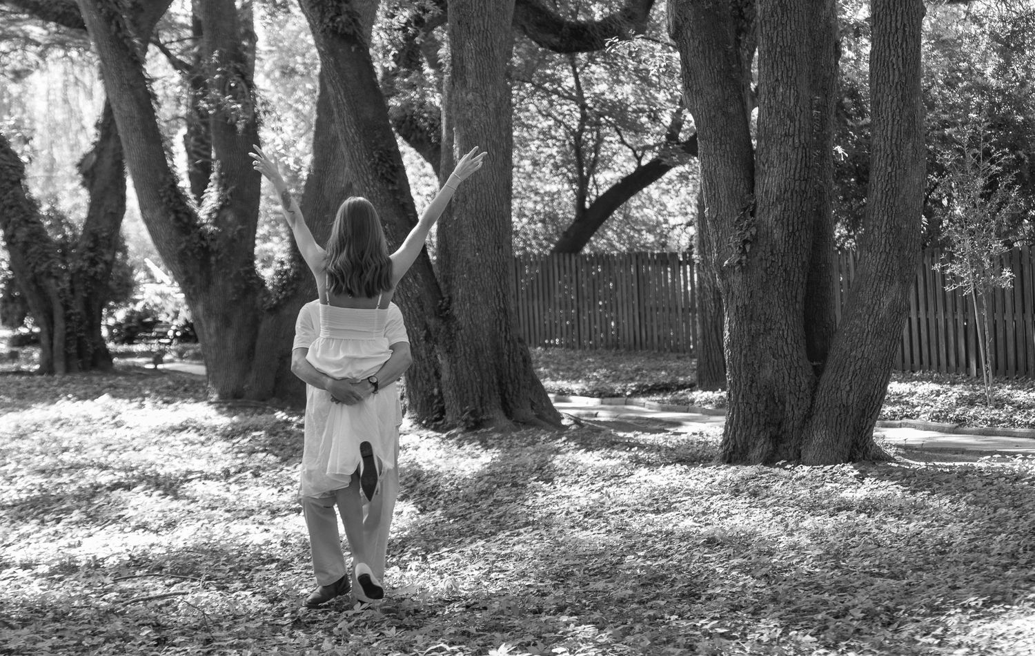 Black and white portrait of an engaged woman standing among the trees during an Aiken, South Carolina engagement session.