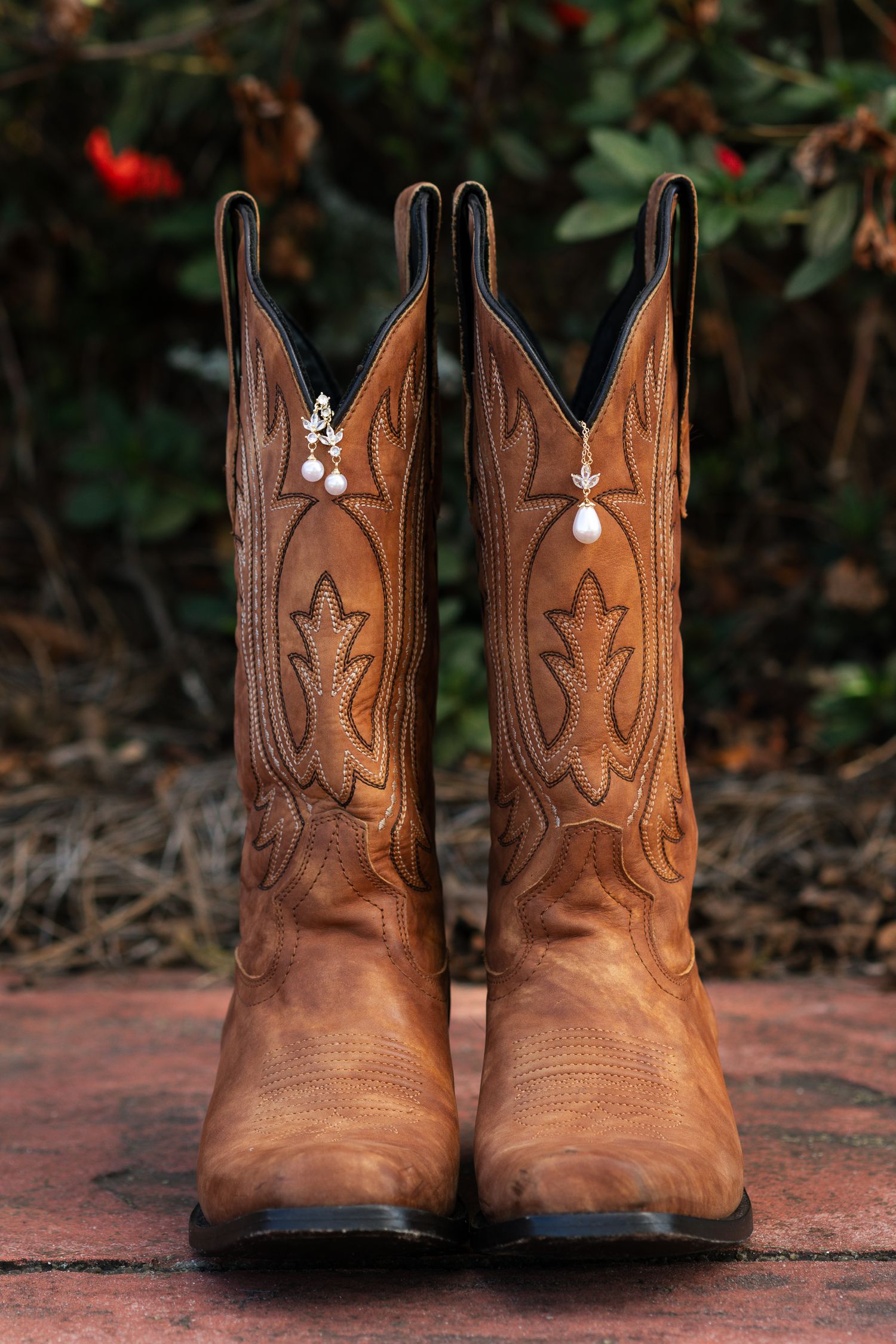 Four identical views of a pair of brown leather cowboy boots with decorative stitching photographed on a brick surface.