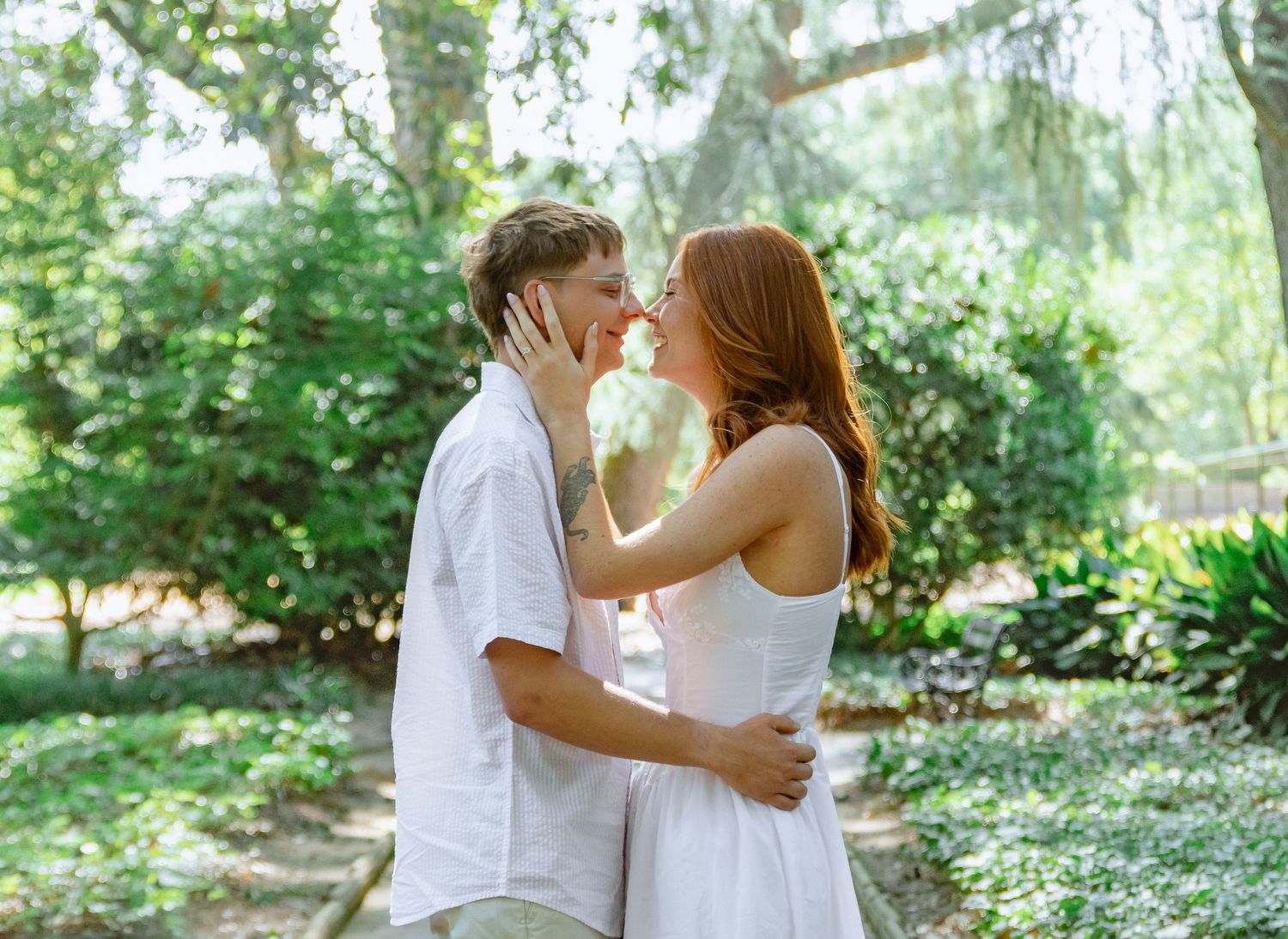 Engaged couple sharing a kiss among the trees during an Aiken, South Carolina engagement session.