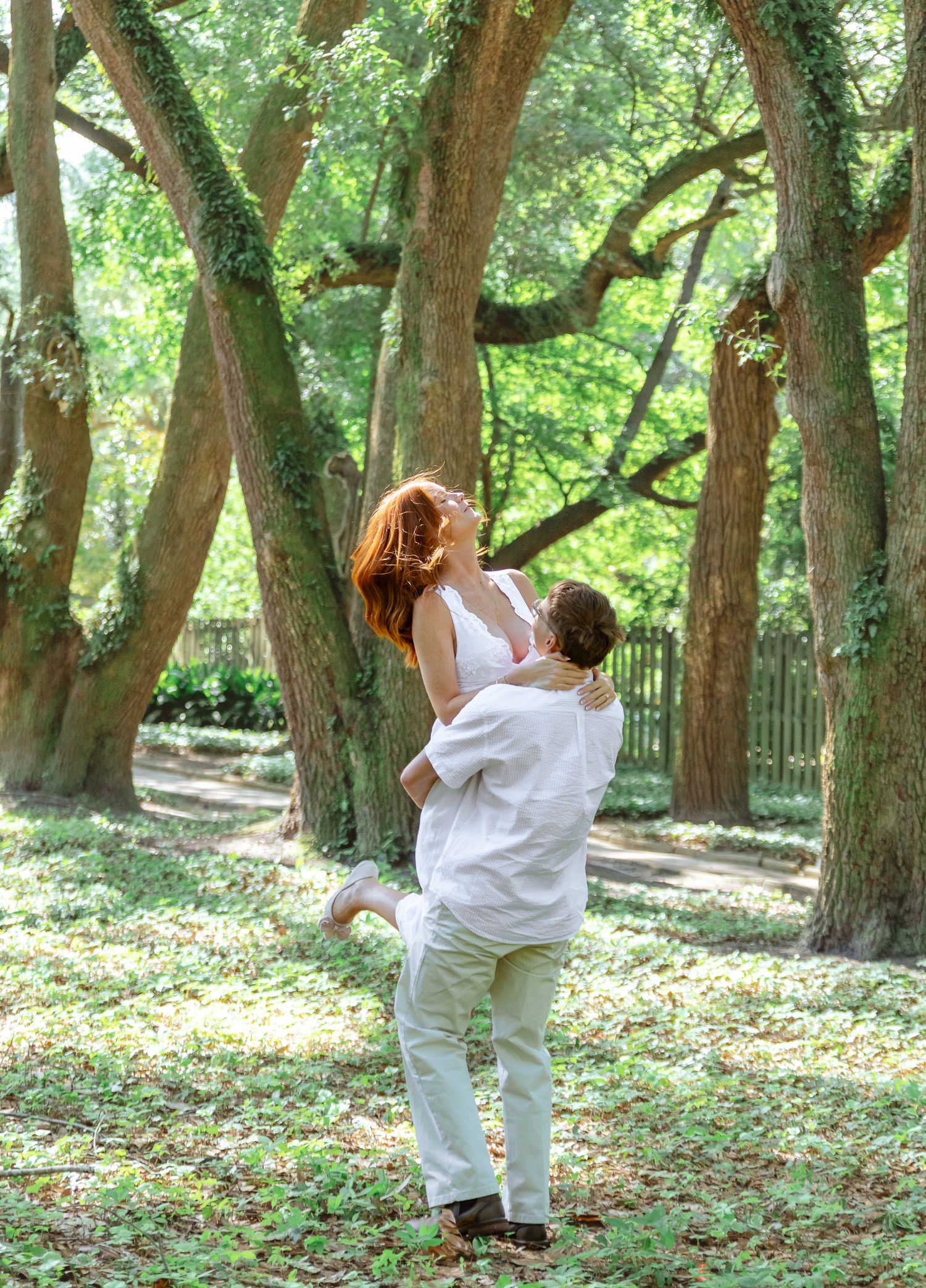 Engaged couple sharing a playful moment as the groom lifts his partner during an Aiken, South Carolina engagement session.