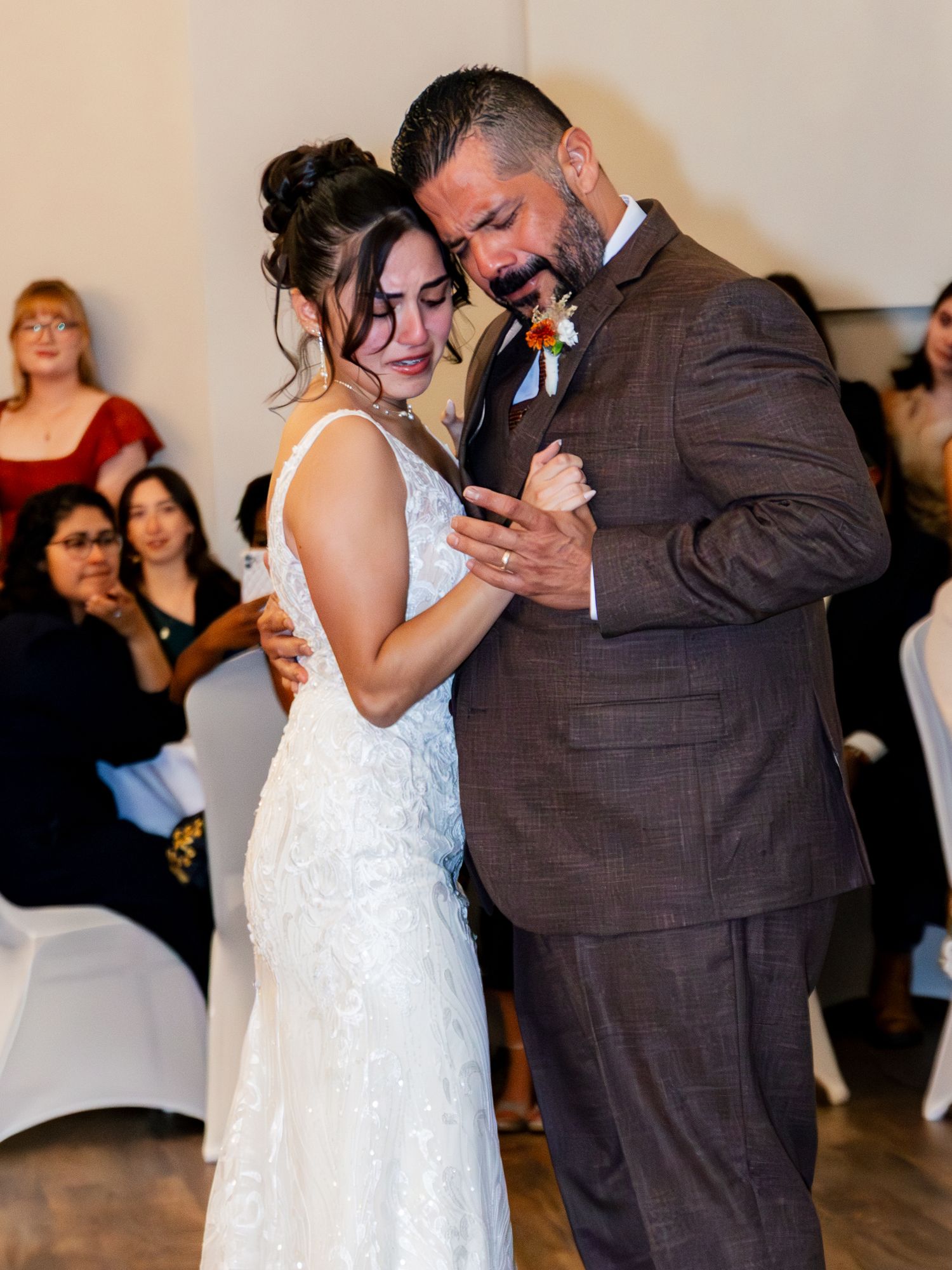 A couple dances together at their wedding reception while guests look on from their seats in the background. Lexington Wedding Photographer