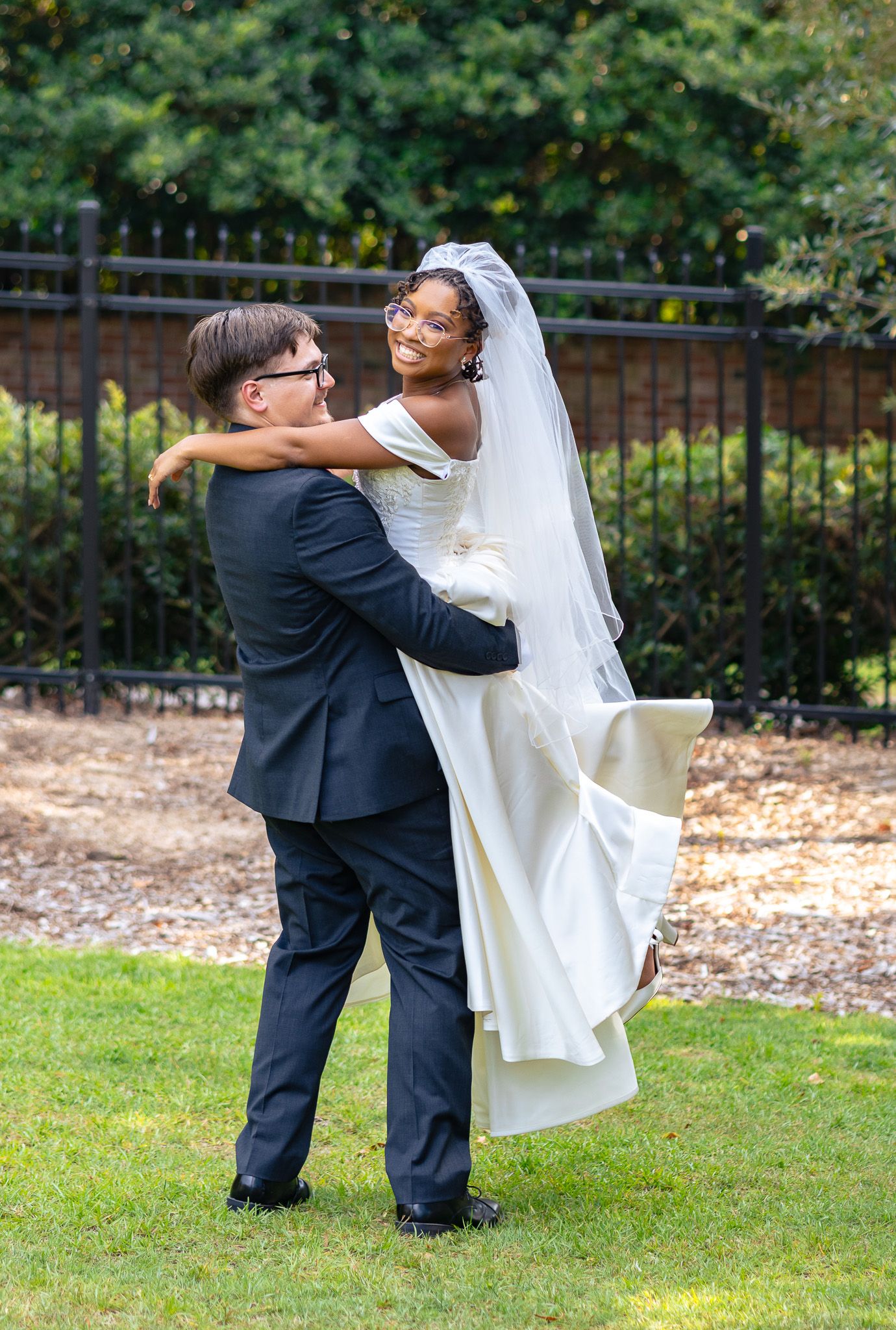 Bride and groom embracing on their wedding day, with the groom lifting the bride in celebration at their Aiken South Carolina Wedding venue.