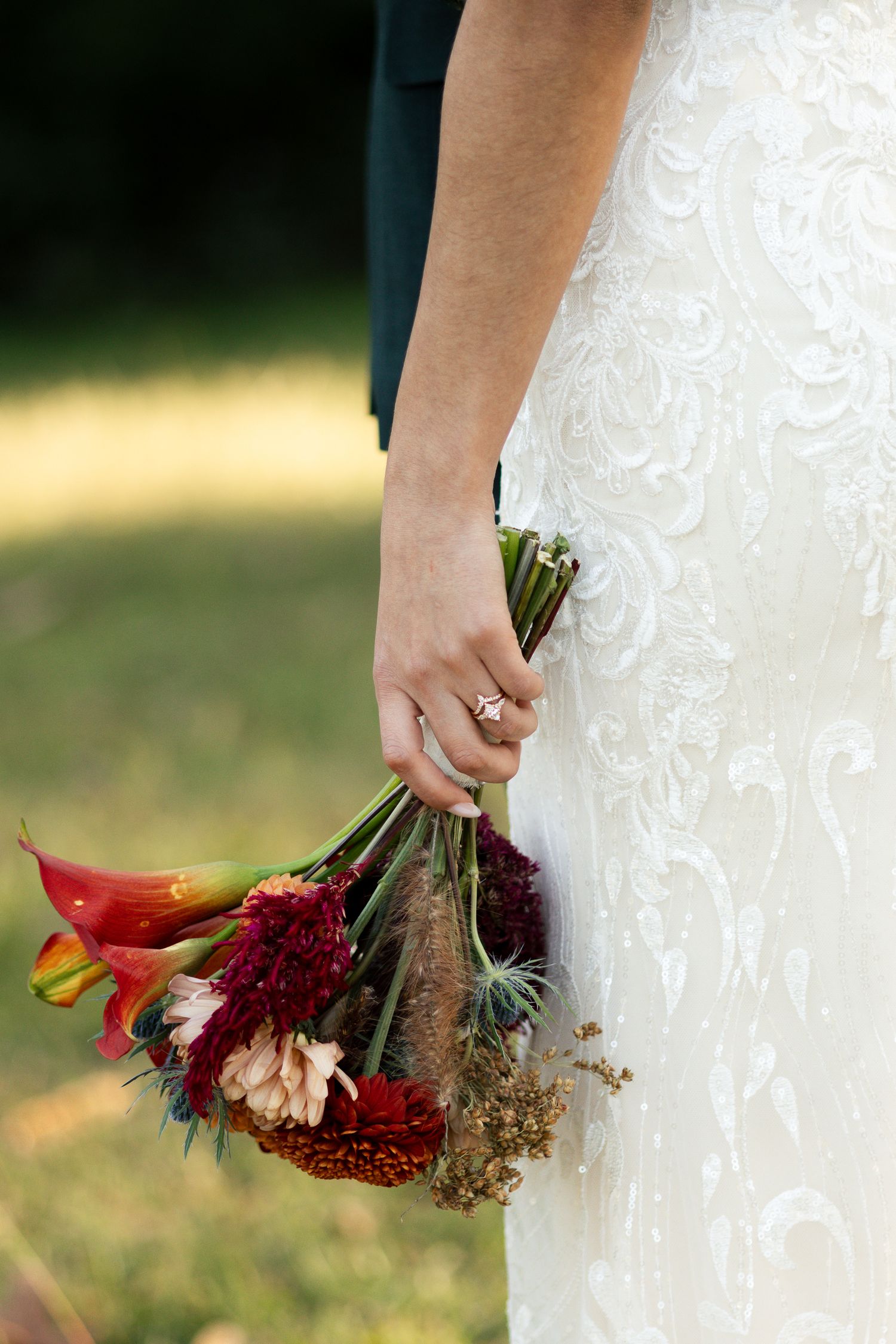 Bride in a lace wedding dress holding a deep burgundy and red bouquet at a Lexington, South Carolina wedding.