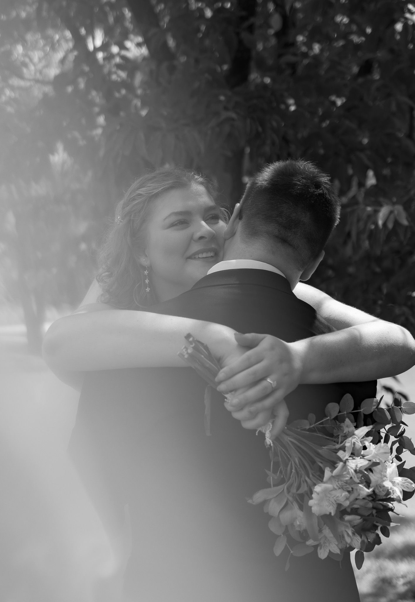 Black and white wedding portrait of a bride embracing her groom outdoors in South Carolina.
