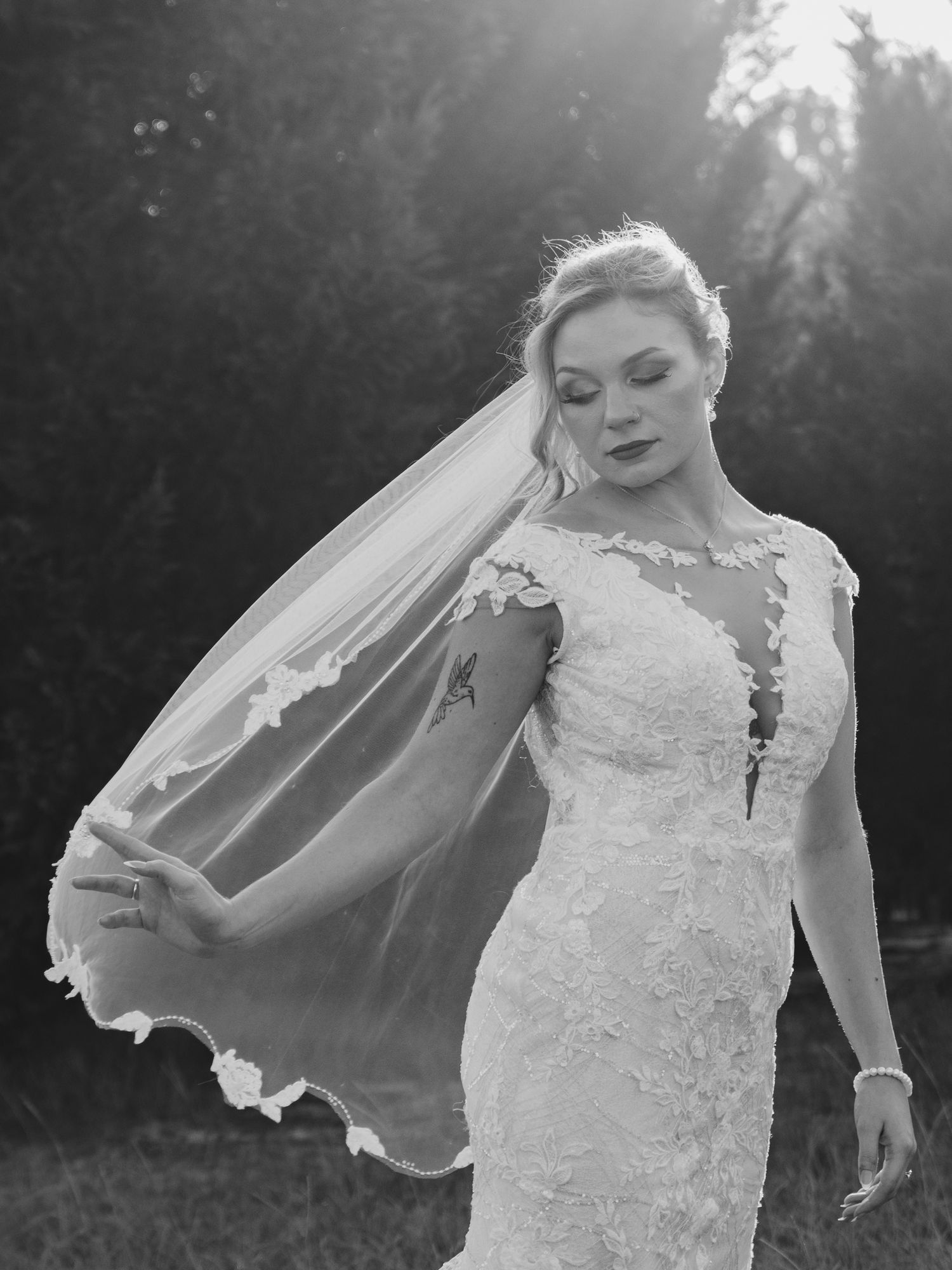 A series of black and white bridal portraits showing a lace wedding dress and flowing veil in natural sunlight.
