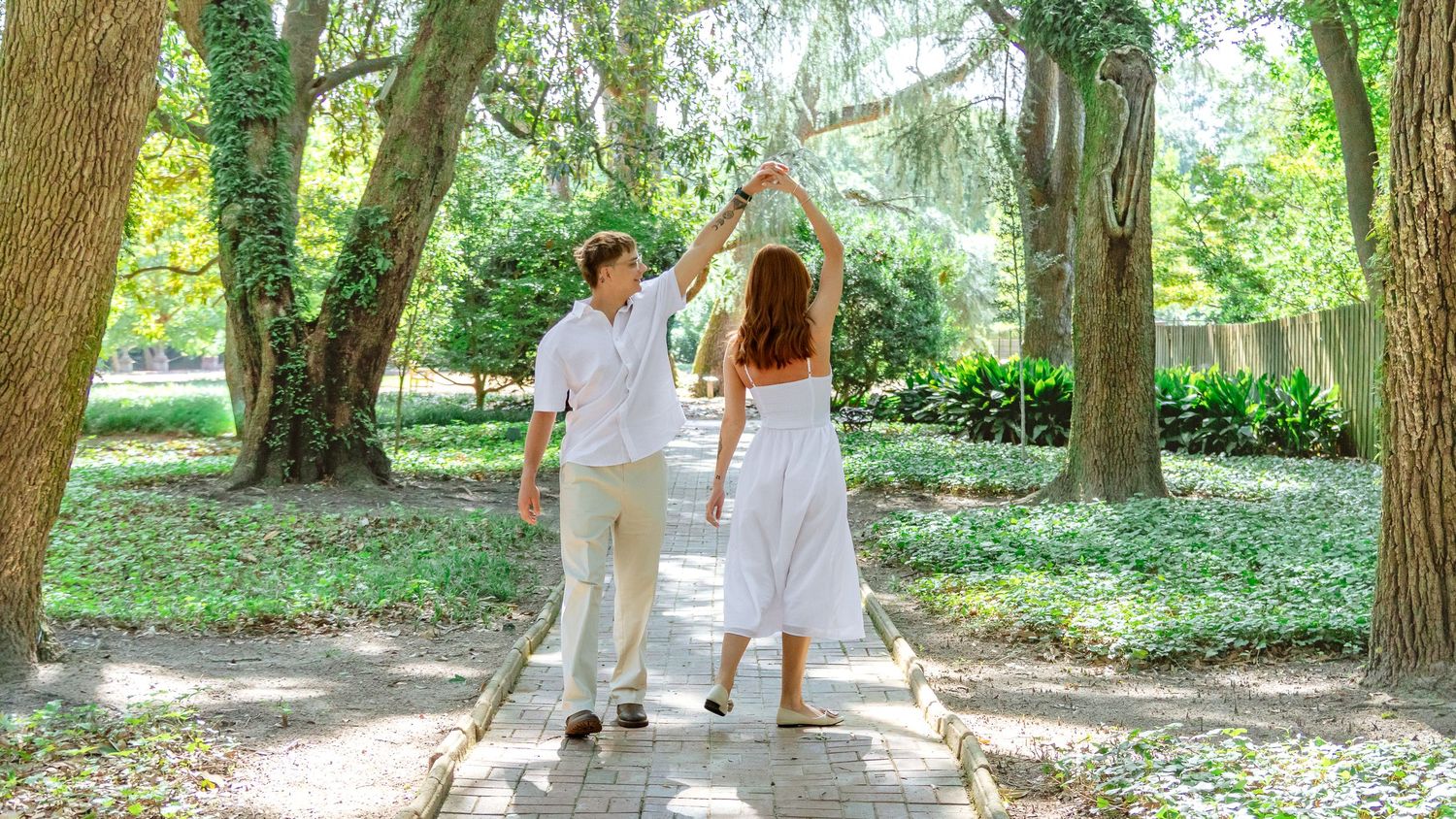 Engaged couple dancing together on a garden path during an Aiken, South Carolina engagement session.