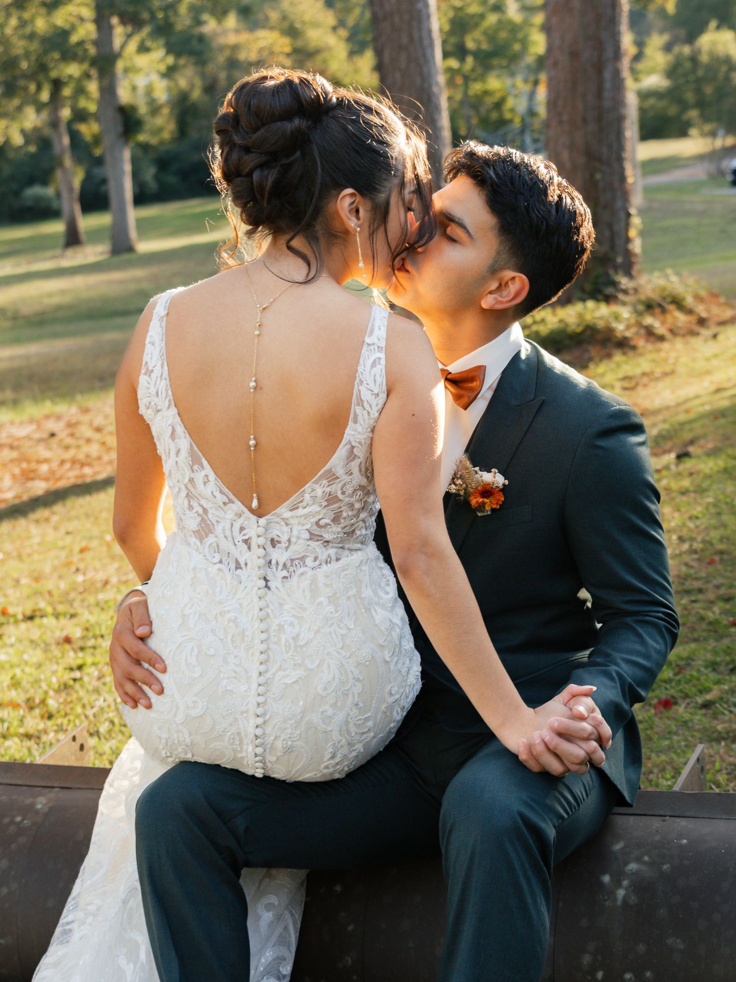 Romantic wedding couple sharing intimate moments on a park bench surrounded by autumn trees at sunset. South Carolina Wedding Photographer