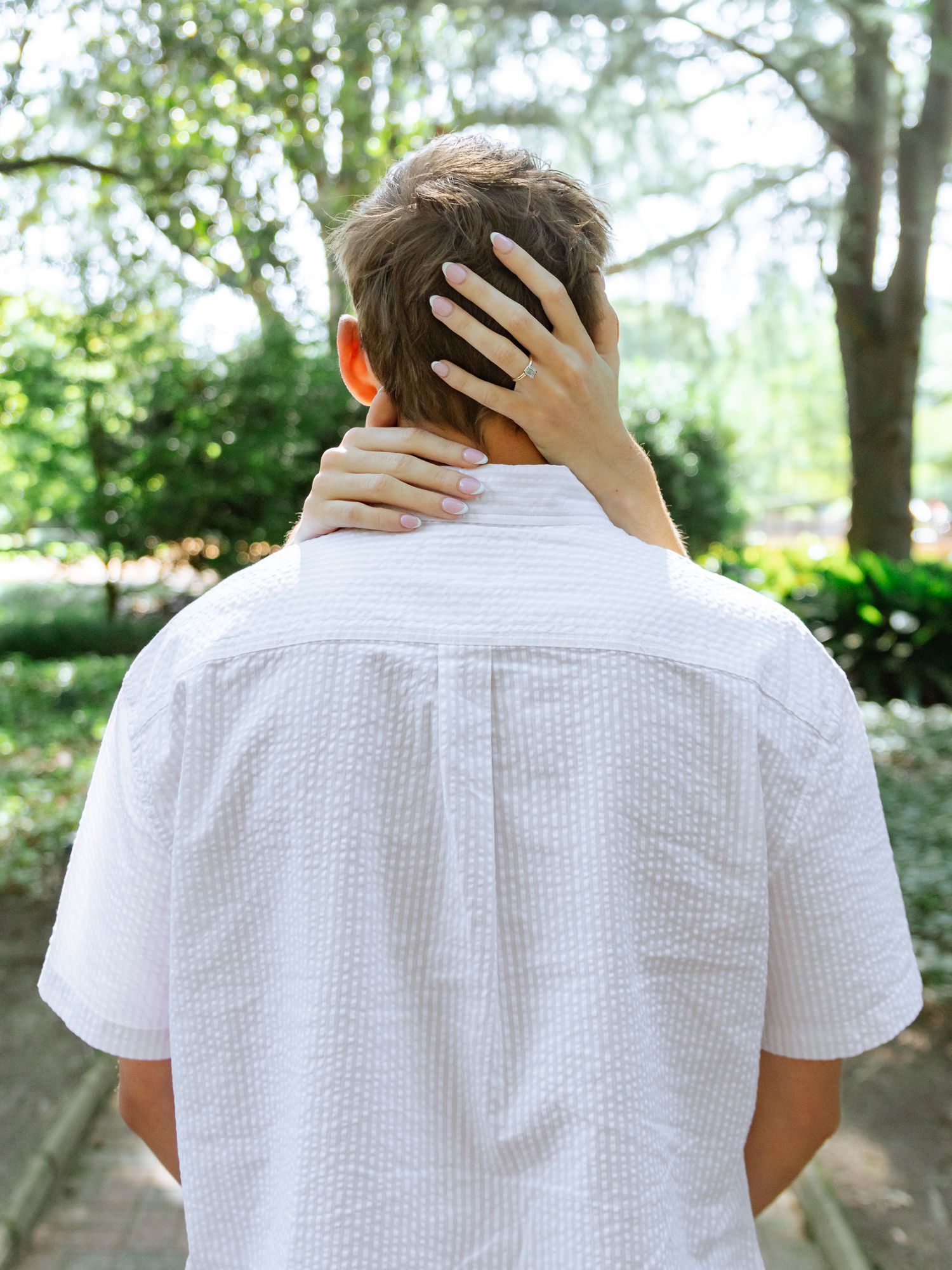 Couple sharing a tender moment during an Aiken, South Carolina engagement session, with the woman resting her hand on his neck.