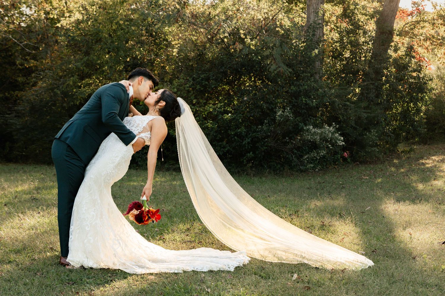 A romantic wedding couple shares a tender moment in a sunlit garden setting during their photo session. South Carolina Wedding Photographer