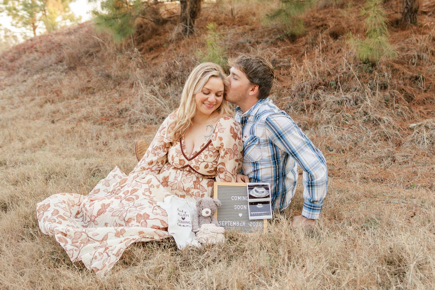 A couple shares romantic moments during a golden hour photoshoot in a rustic outdoor setting with warm autumn colors.