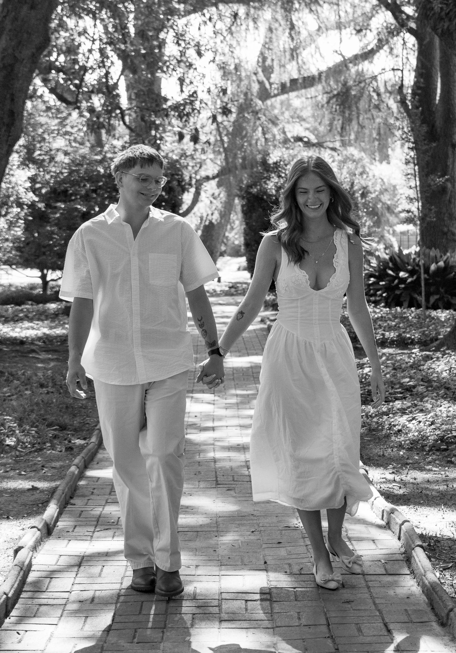Black and white photograph of an engaged couple walking hand in hand during an Aiken, South Carolina engagement session.