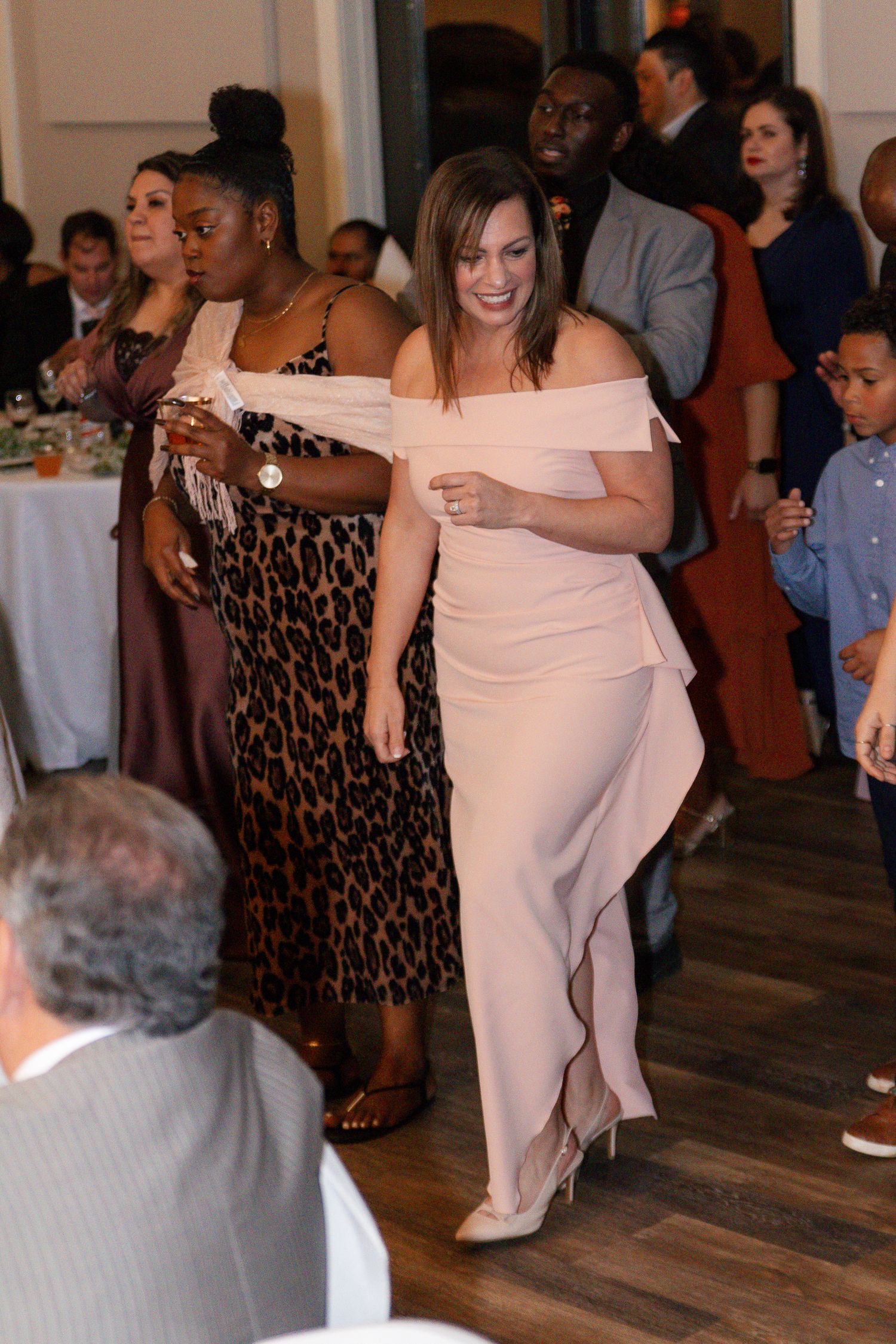 A couple dances together at a wedding reception while other guests in formal attire watch from the sidelines. Lexington Wedding Photographer