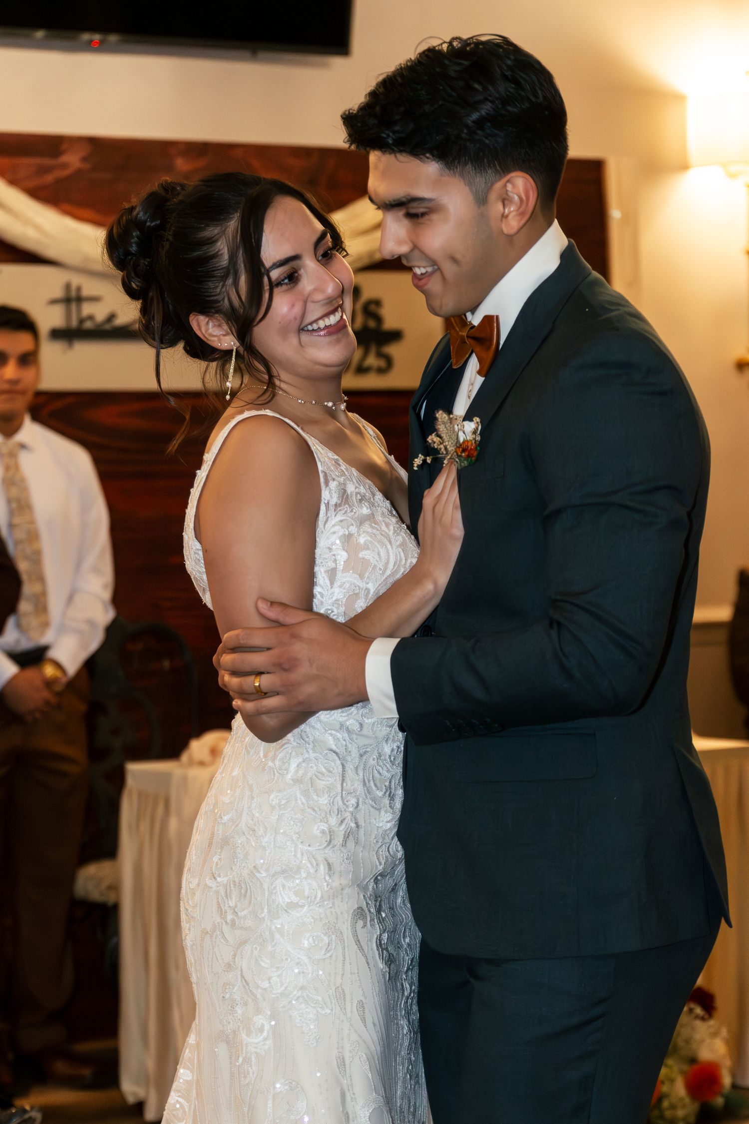A couple shares an intimate moment during their first dance at a wedding reception, with the bride wearing a lace gown. Lexington Wedding