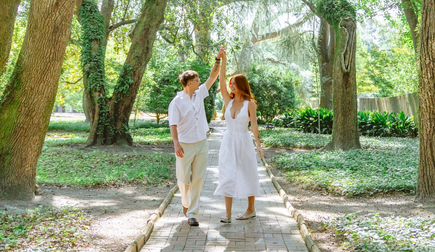 Engaged couple dancing together on a garden path during an Aiken, South Carolina engagement session.