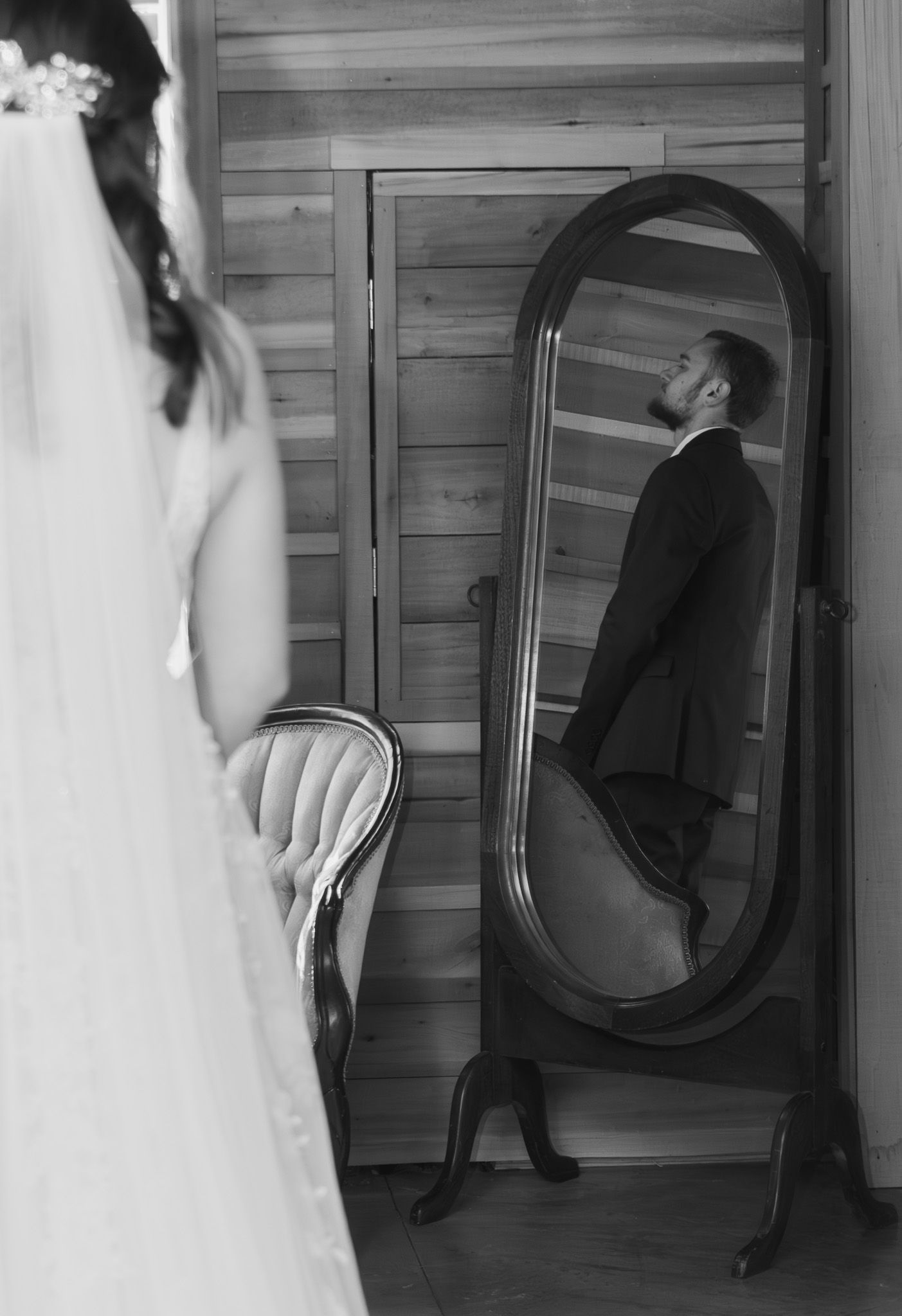 Black and white portrait of a groom looking in a mirror before his Batesburg, South Carolina wedding ceremony.