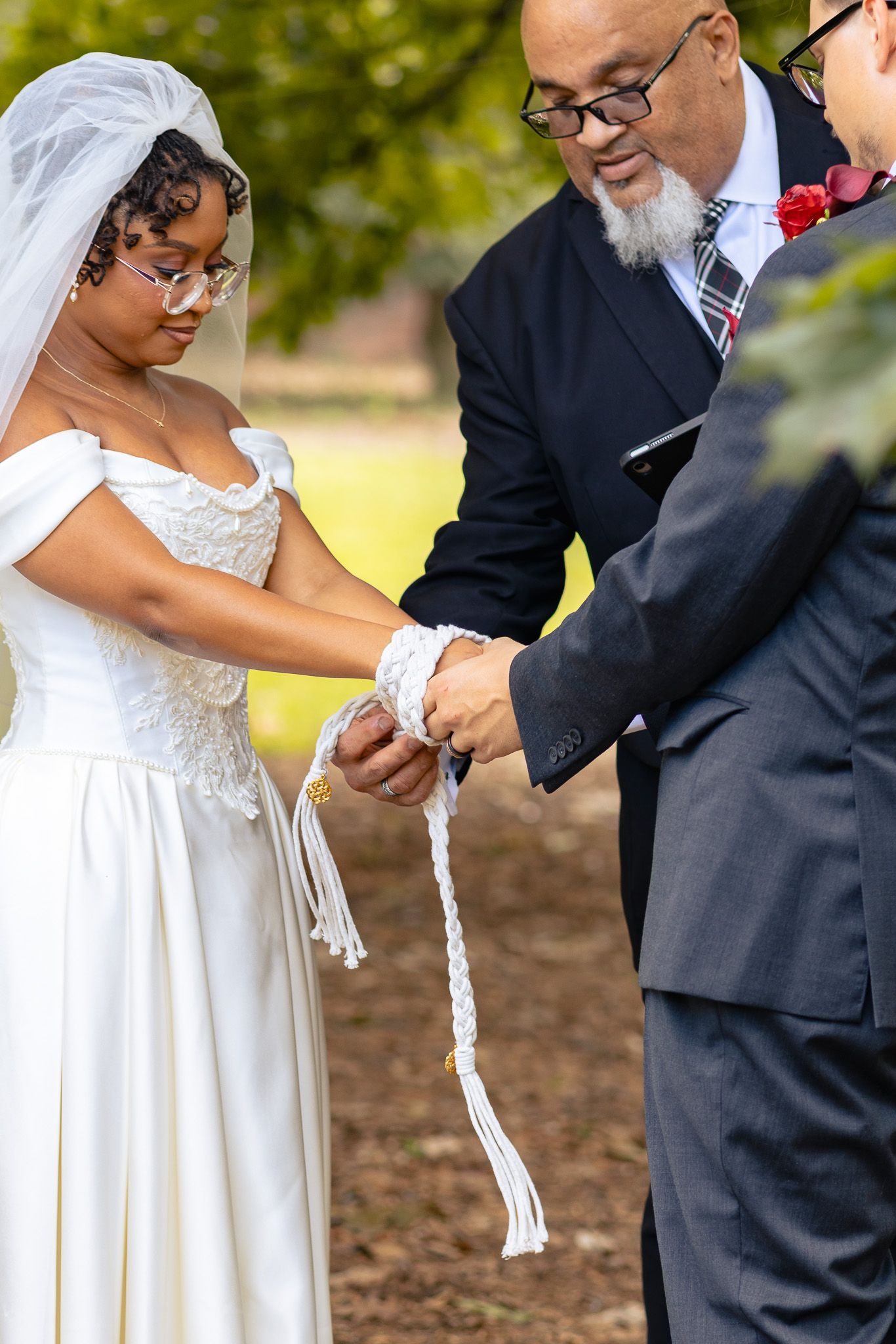 Bride and groom participating in an outdoor handfasting ceremony at their Aiken South Carolina Wedding Venue.