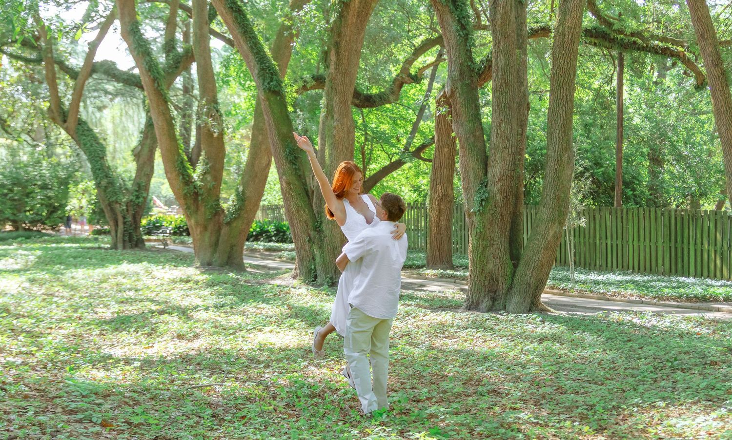 Engaged couple dancing together among the trees during an Aiken, South Carolina engagement session.