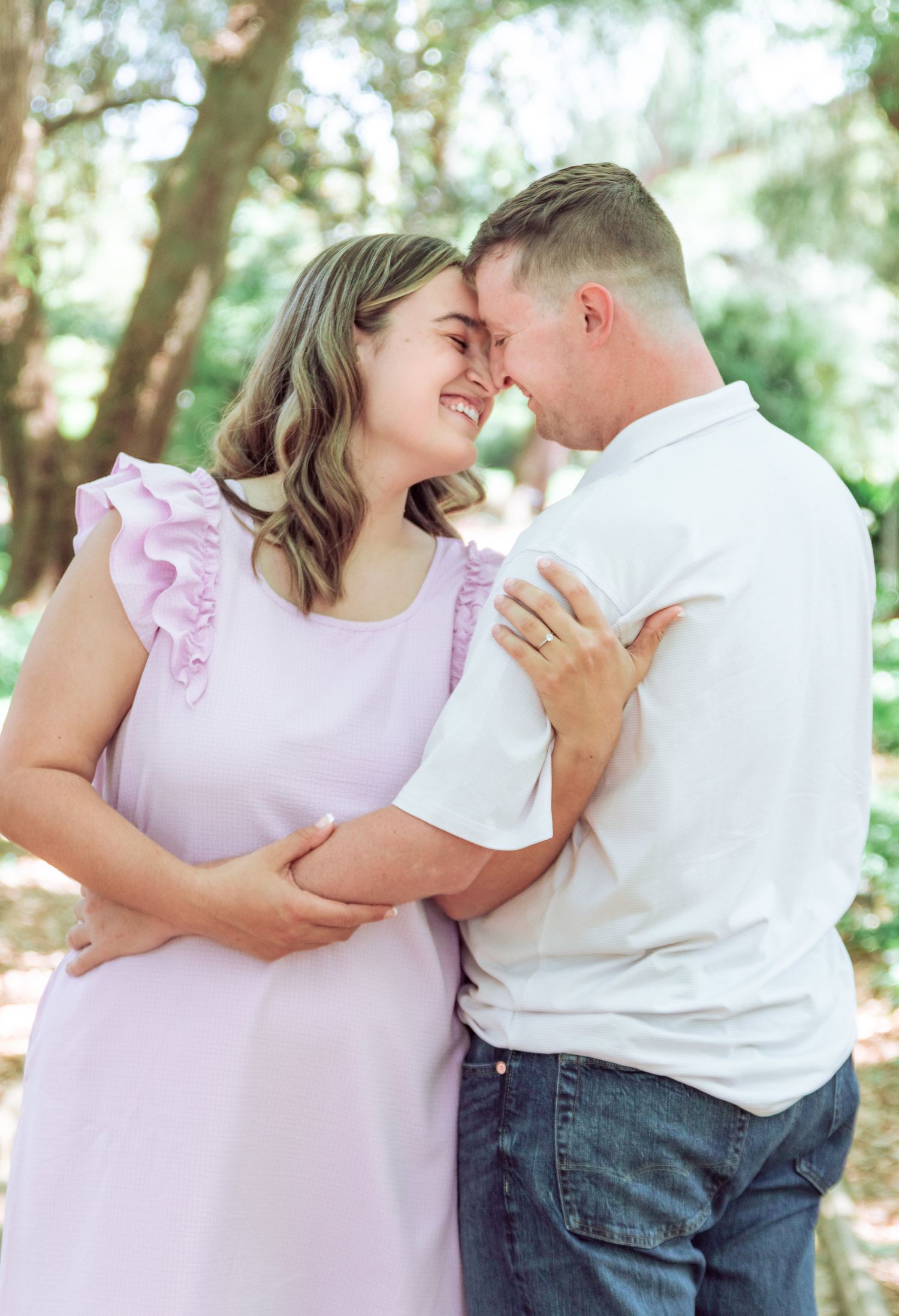 Engaged couple sharing a tender moment in a park during an Aiken, South Carolina engagement session.