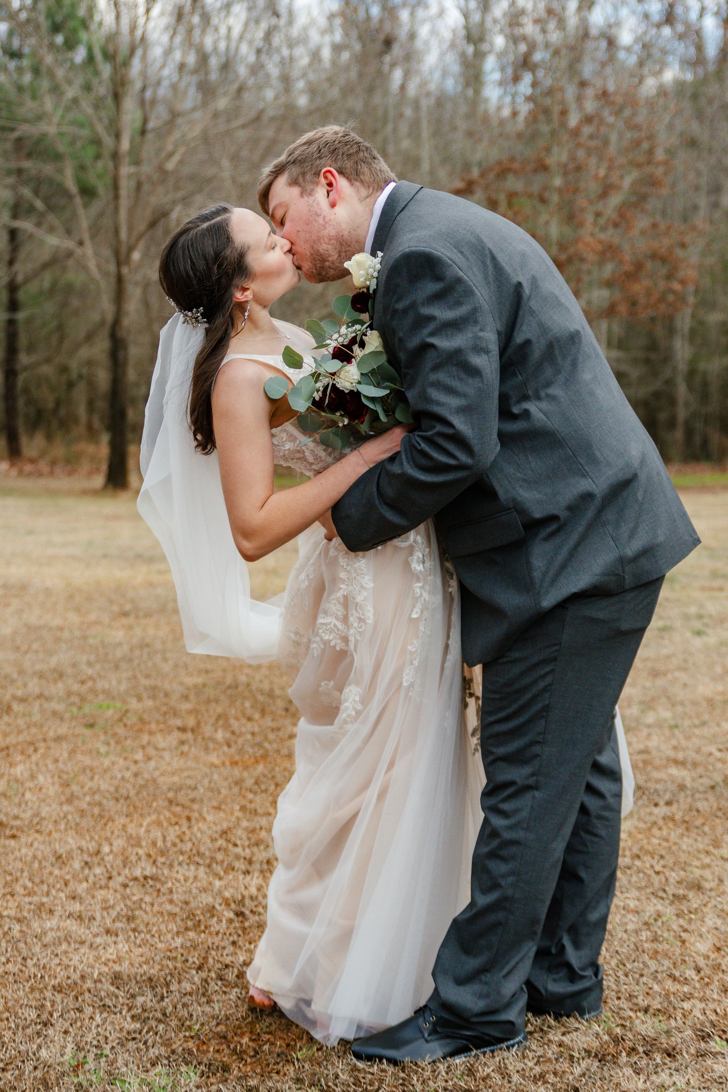 A series of romantic wedding photos showing a couple in formal attire sharing tender moments outdoors in a wooded setting.