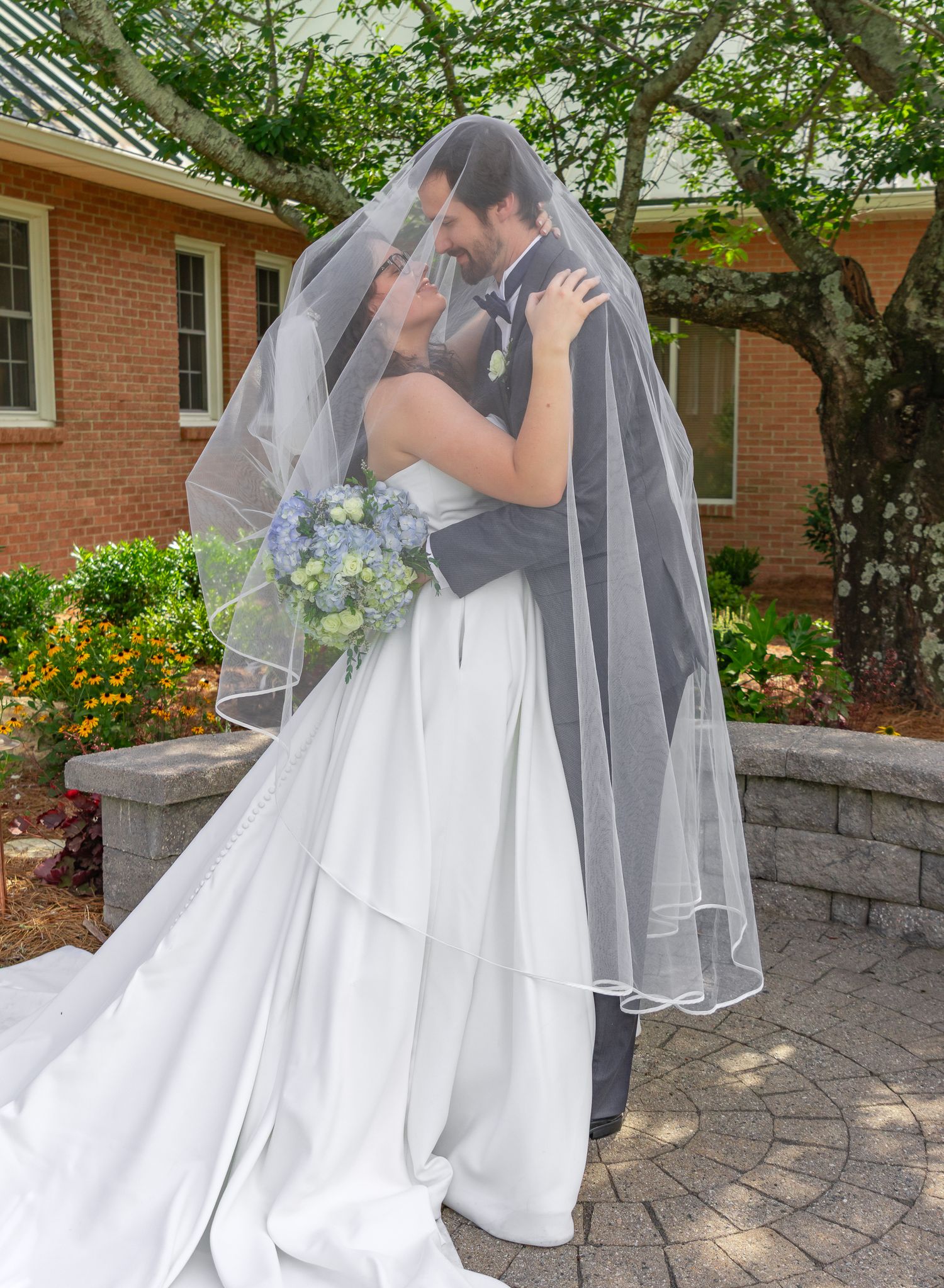 Bride and groom sharing a romantic kiss beneath a flowing veil on their South Carolina wedding day.