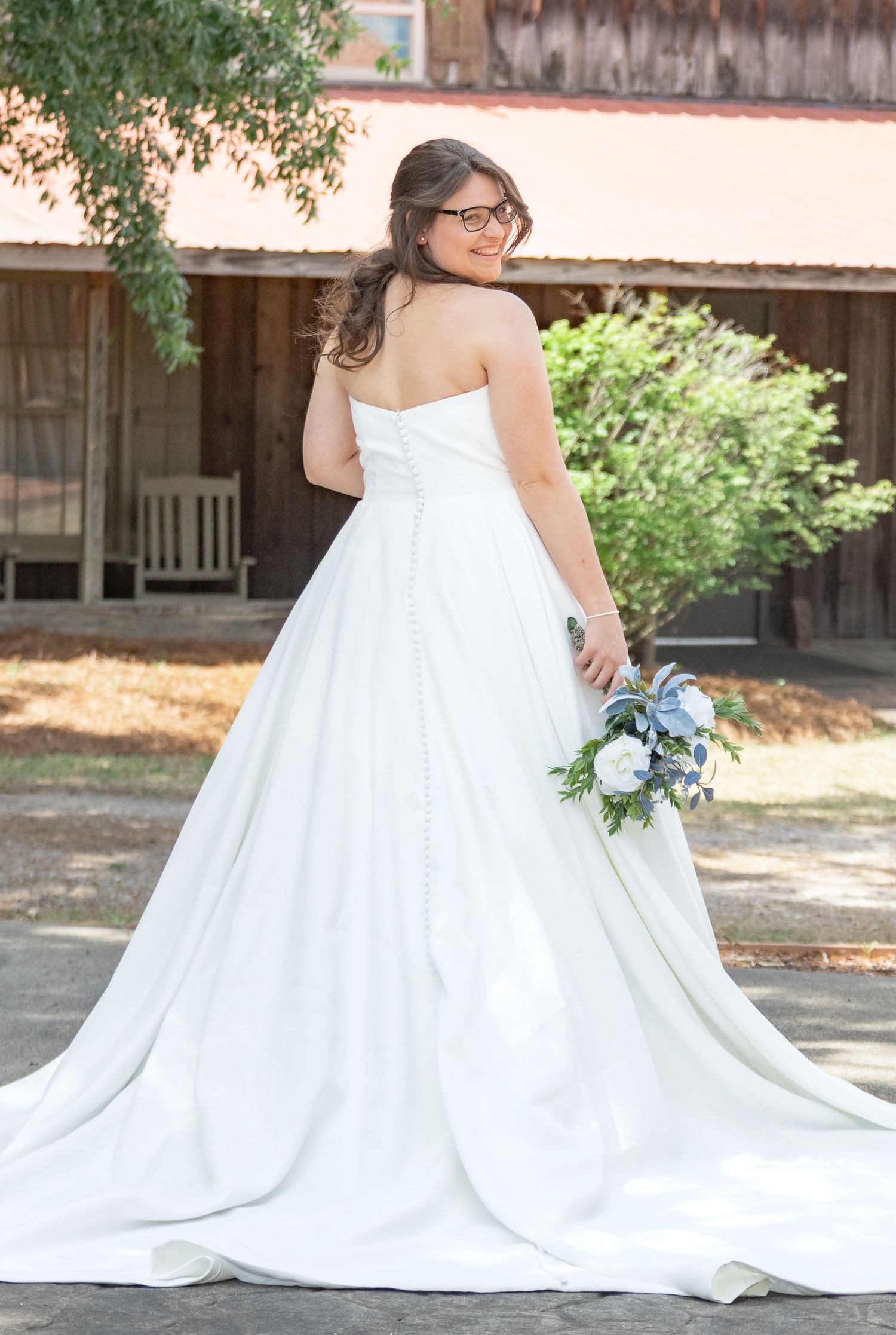 Bride in a strapless white ball gown holding a blue bouquet during a South Carolina bridal portrait session.