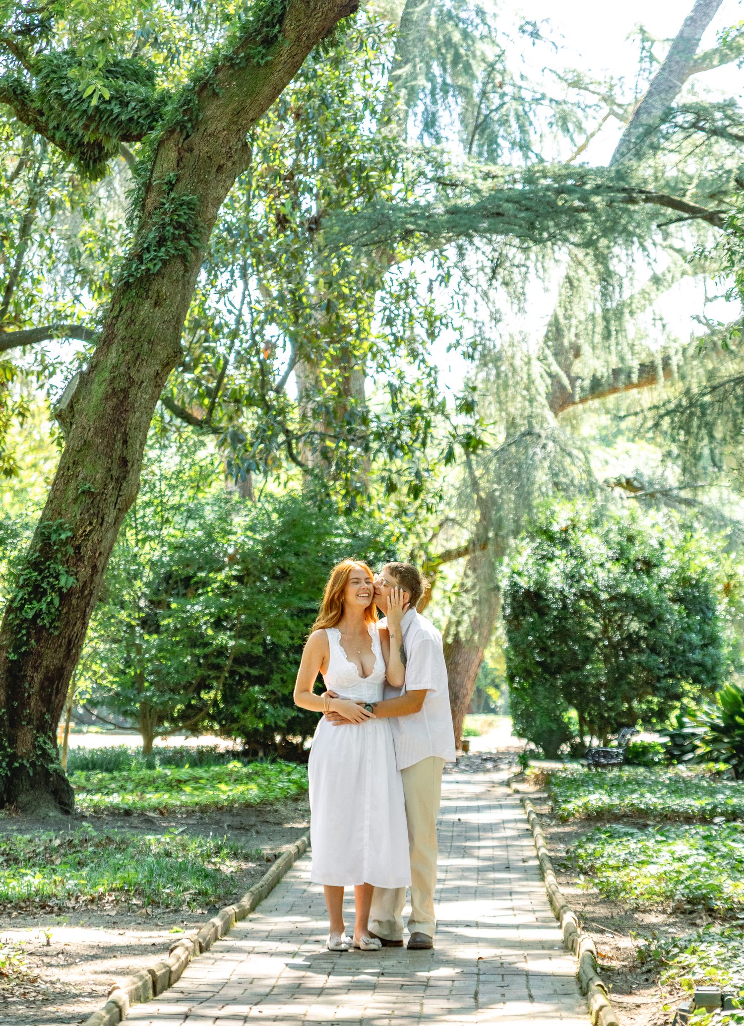 Engaged couple sharing a sweet moment on a garden path during an Aiken, South Carolina engagement session.