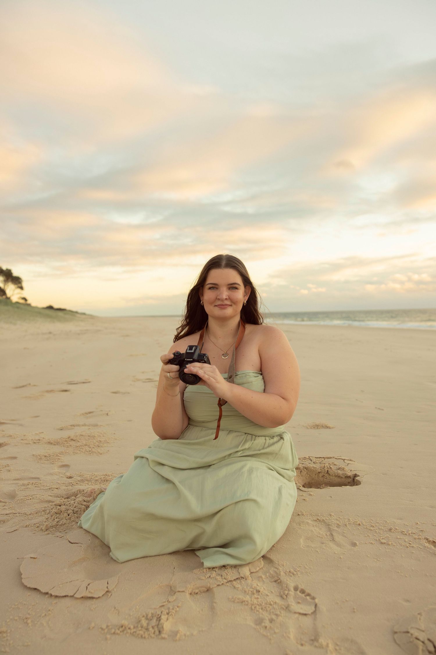 Local Bribie Island photographer on beach holding camera.