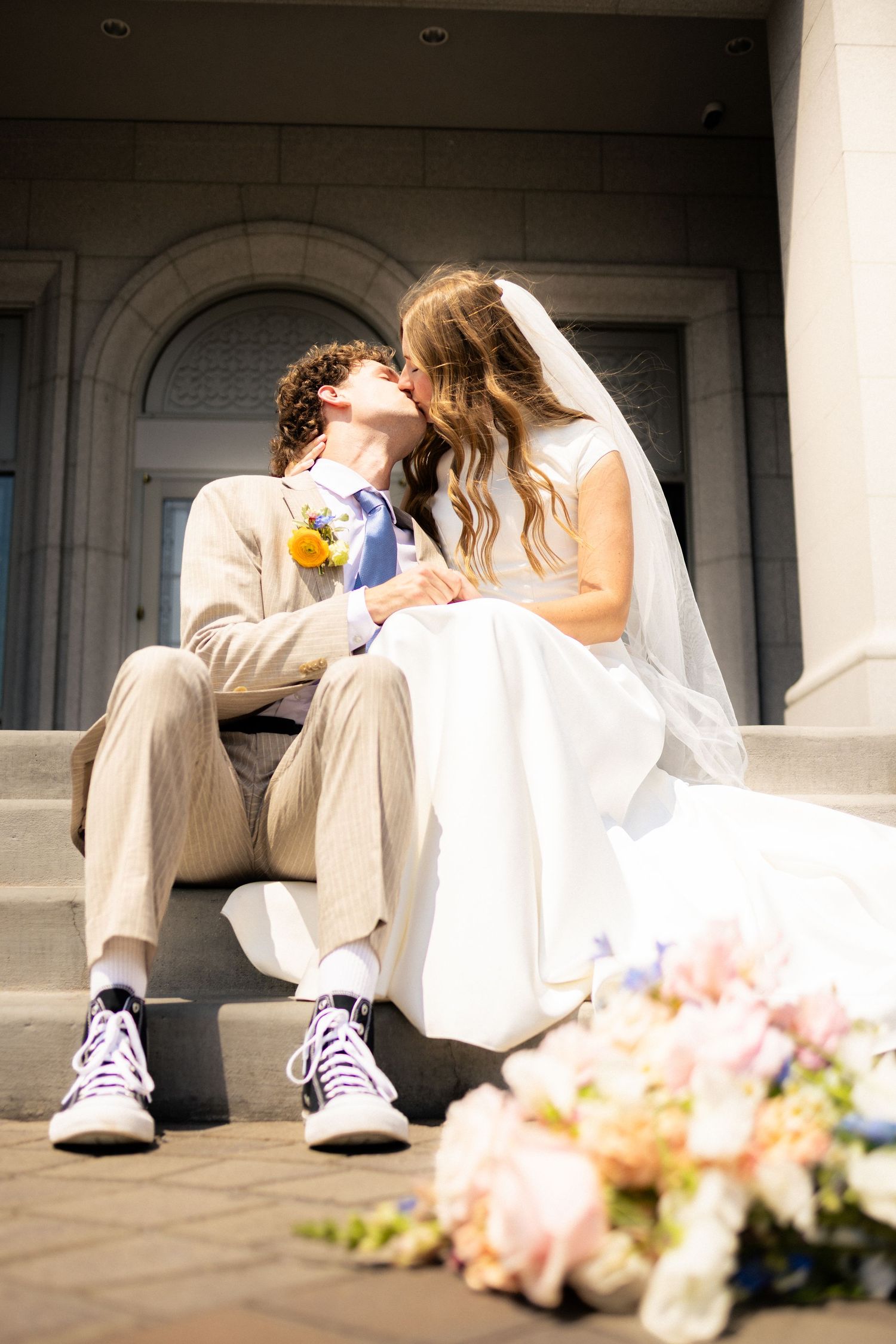Bride and groom sit outside the Orem Temple in Utah County.