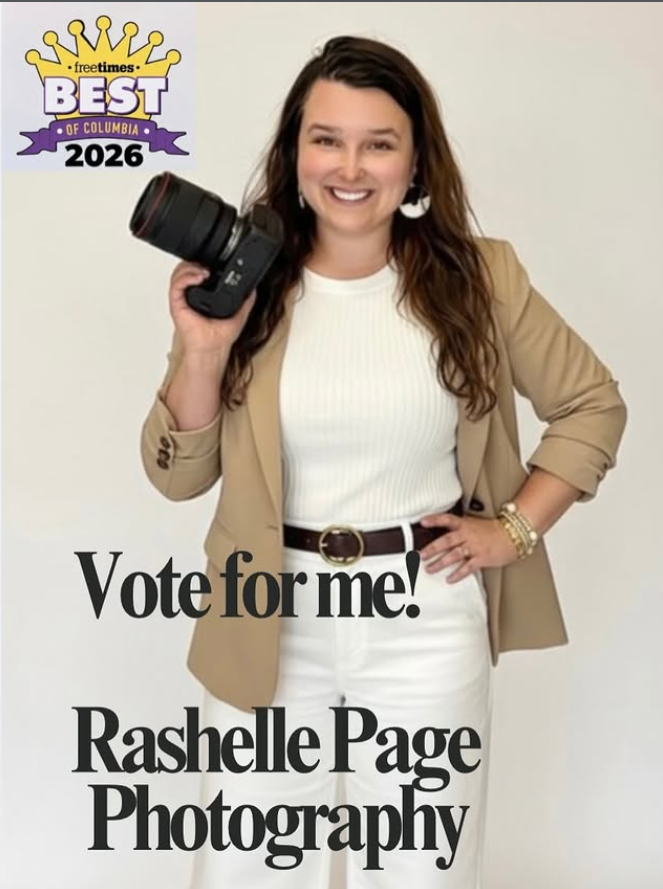 Woman holding camera promoting Rashelle Page Photography, voted Best of Columbia 2026, wearing tan blazer.