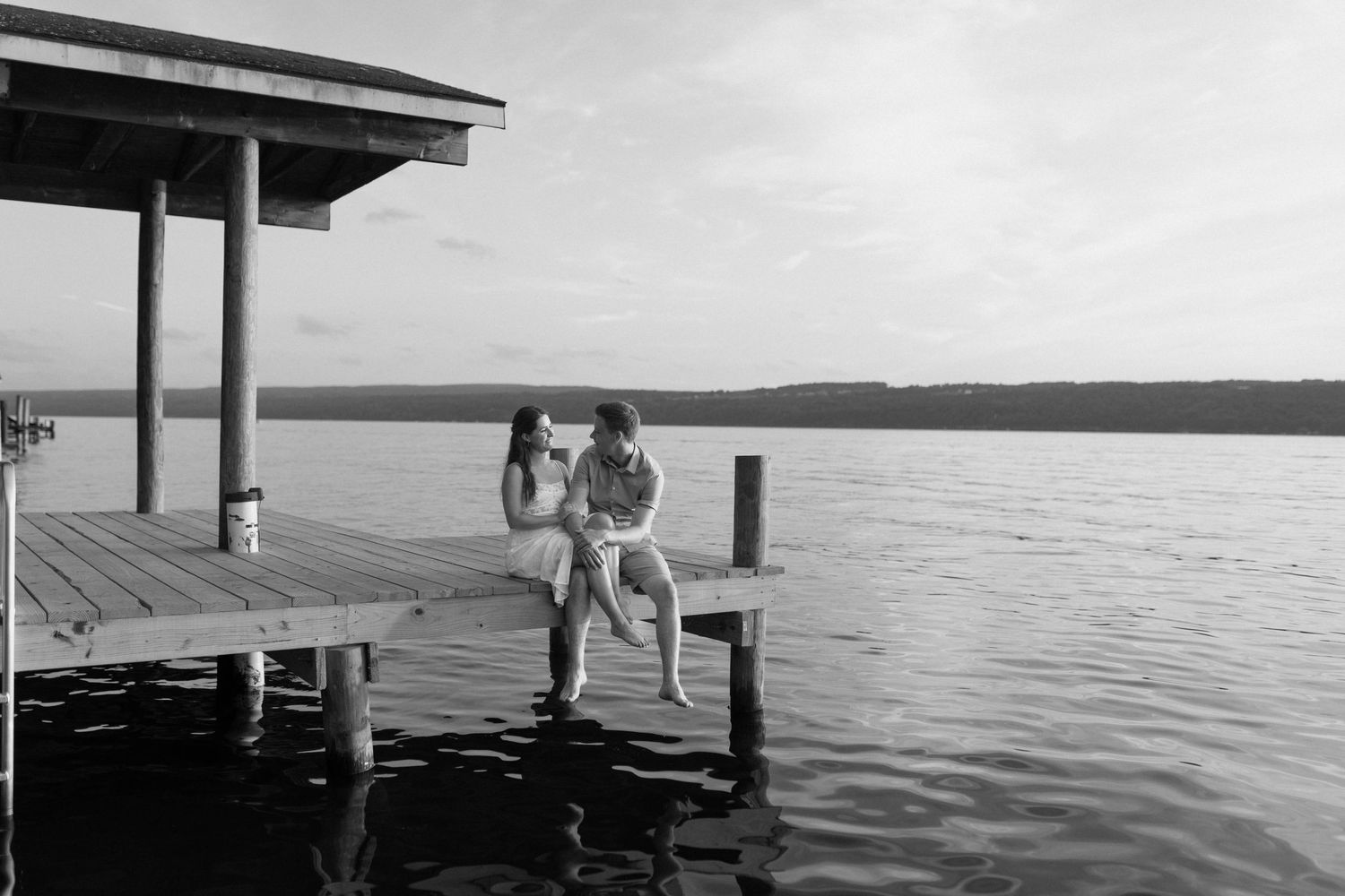 A series of black and white photos showing people enjoying leisure activities on a dock by a calm lake.