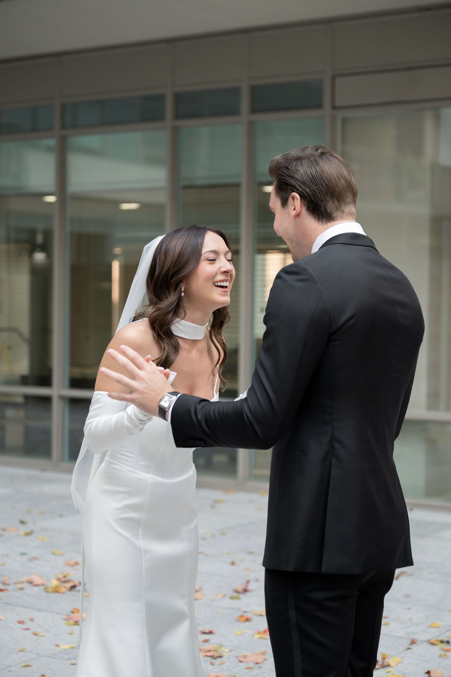 A candid moment of joyful laughter shared between a couple in wedding attire.