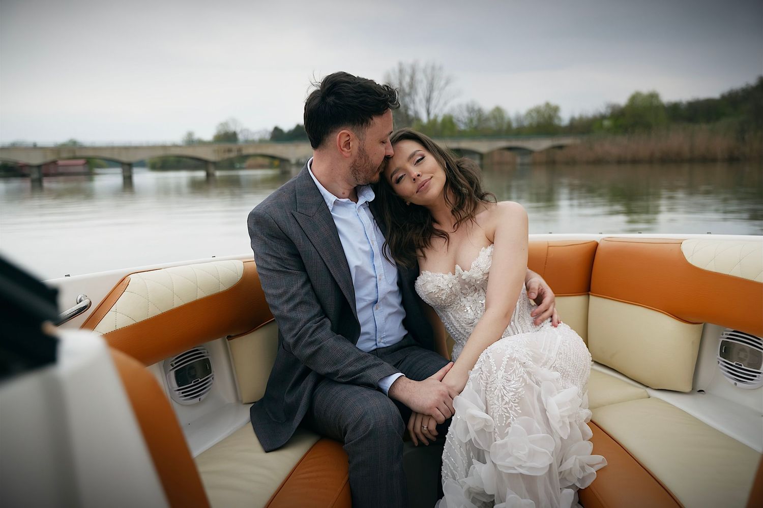 Capture the tranquility and romance of your wedding day with the bride and groom on a boat, creating a peaceful and unforgettable moment.