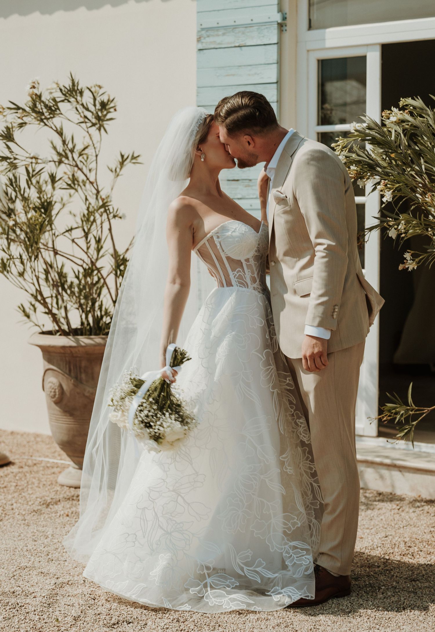 Capture the love and romance of your special day with a beautiful moment of the bride and groom kissing, creating a timeless wedding photo.