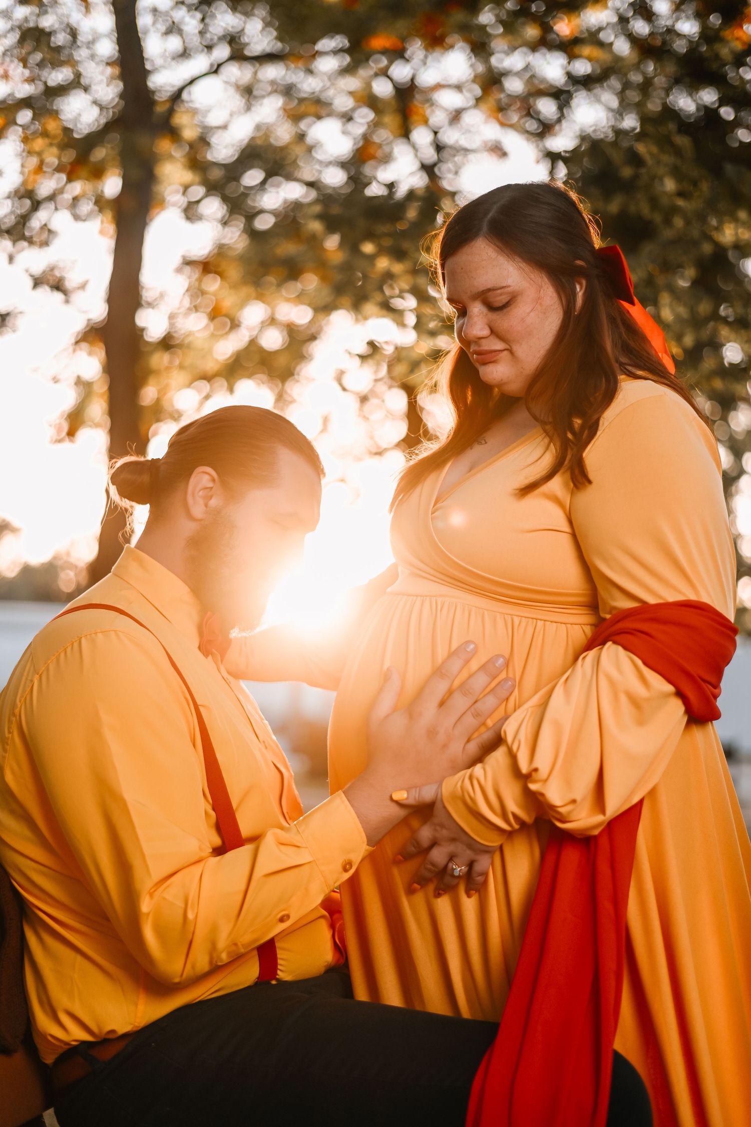 A couple in yellow and red clothing embraces tenderly during golden hour sunset in a romantic photo series.