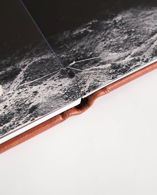 Detail view of a layflat photo album spine and thick printed pages.