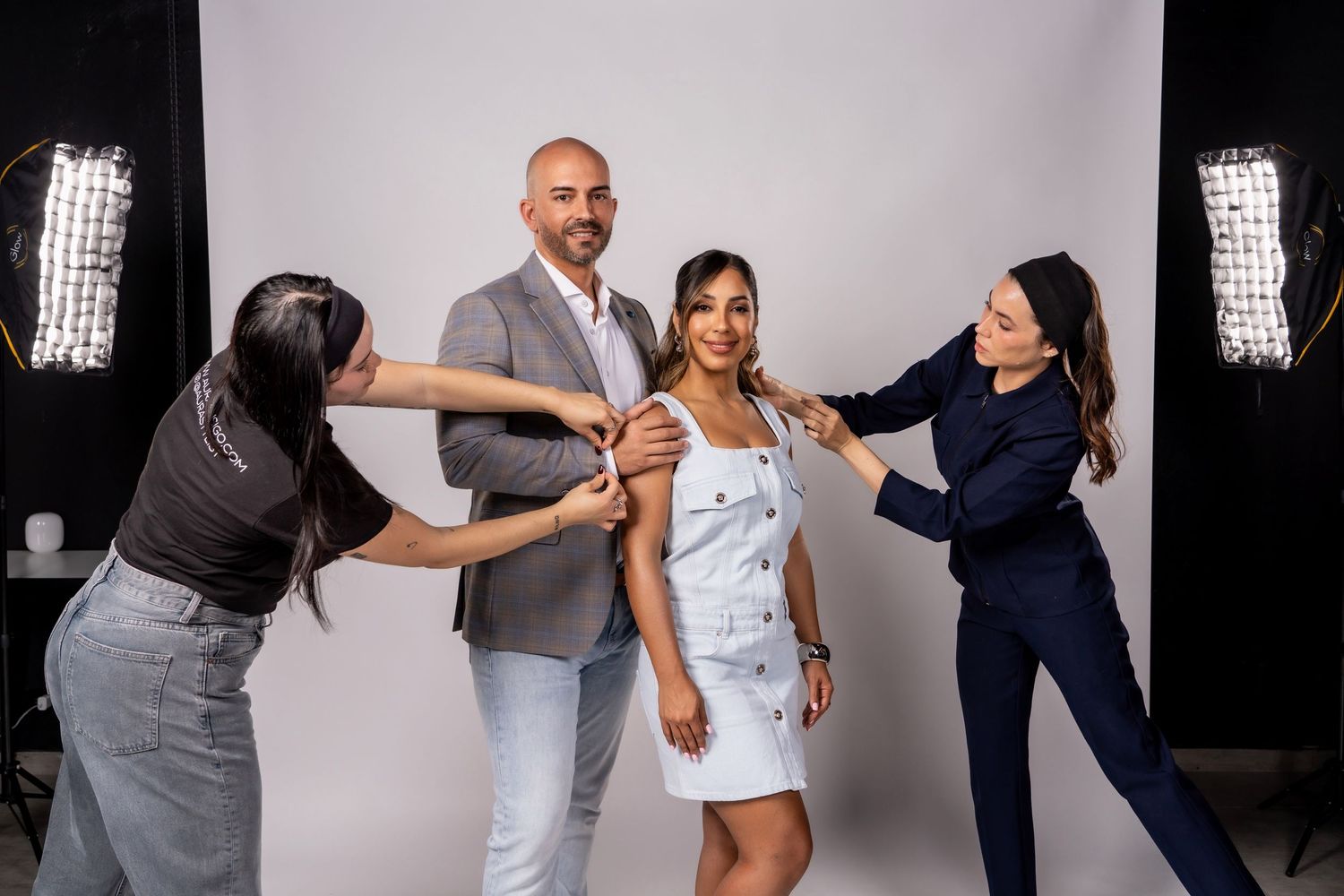 Behind the scenes photo shoot with styling team working in studio setting.