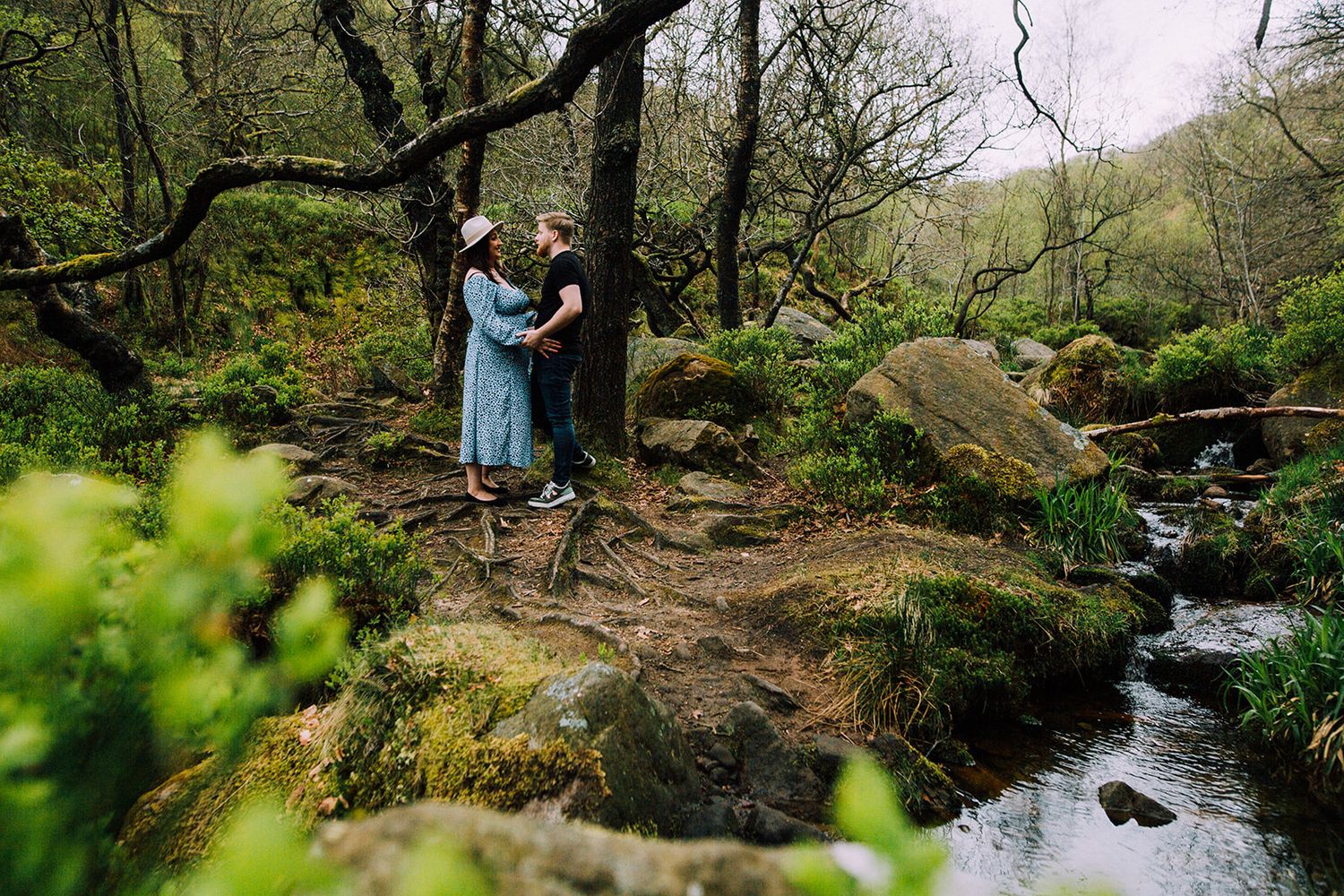 A series of forest stream views with hikers exploring mossy rocks and flowing water in a lush woodland setting.