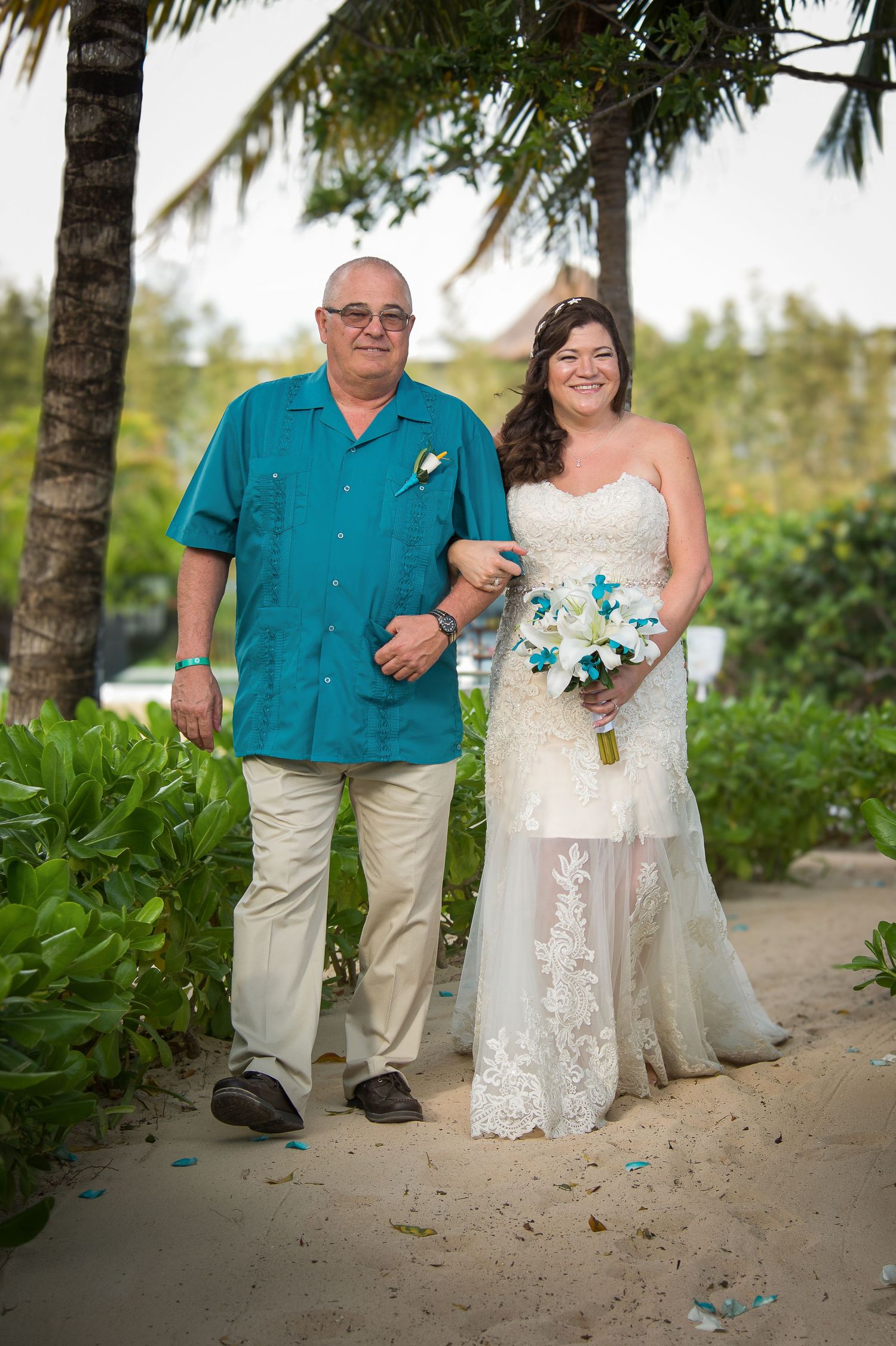 A series of beach wedding photos showing a couple in teal and white attire posing among palm trees and tropical foliage.