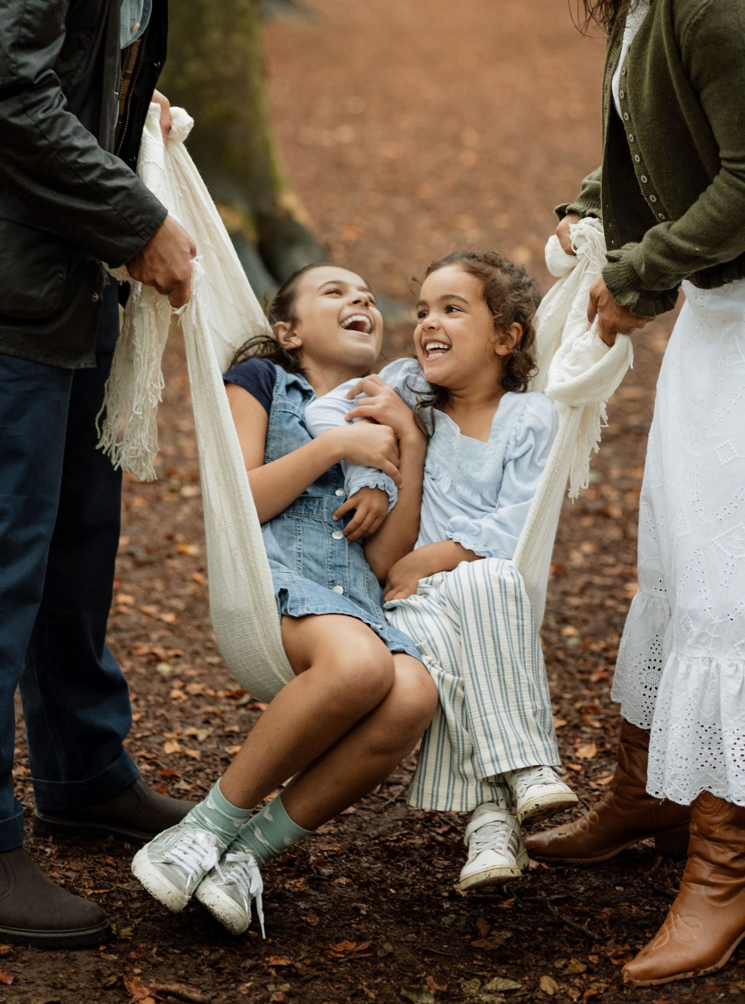 Two sisters laughing together during a child-led family photoshoot near Winchester